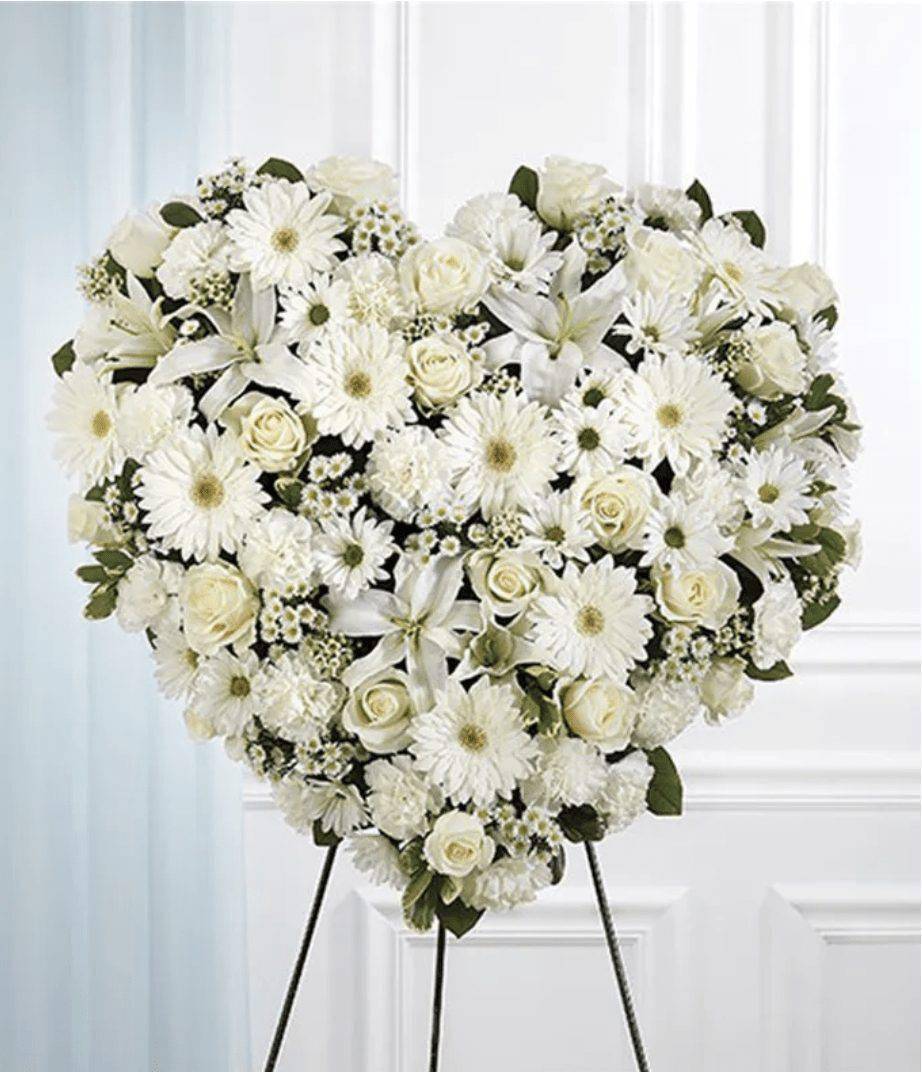 Heart-shaped white floral standing spray on an easel