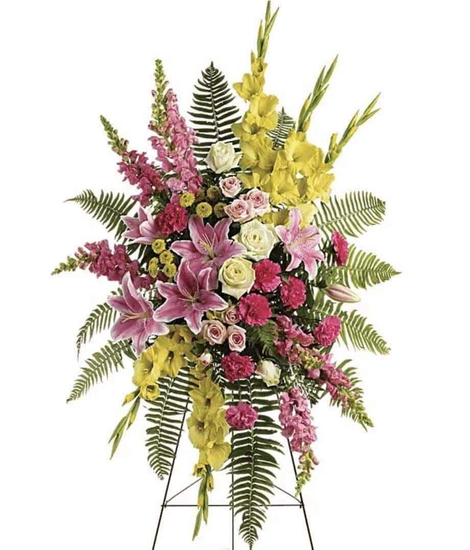 Standing floral spray with pink, yellow, and white flowers on an easel