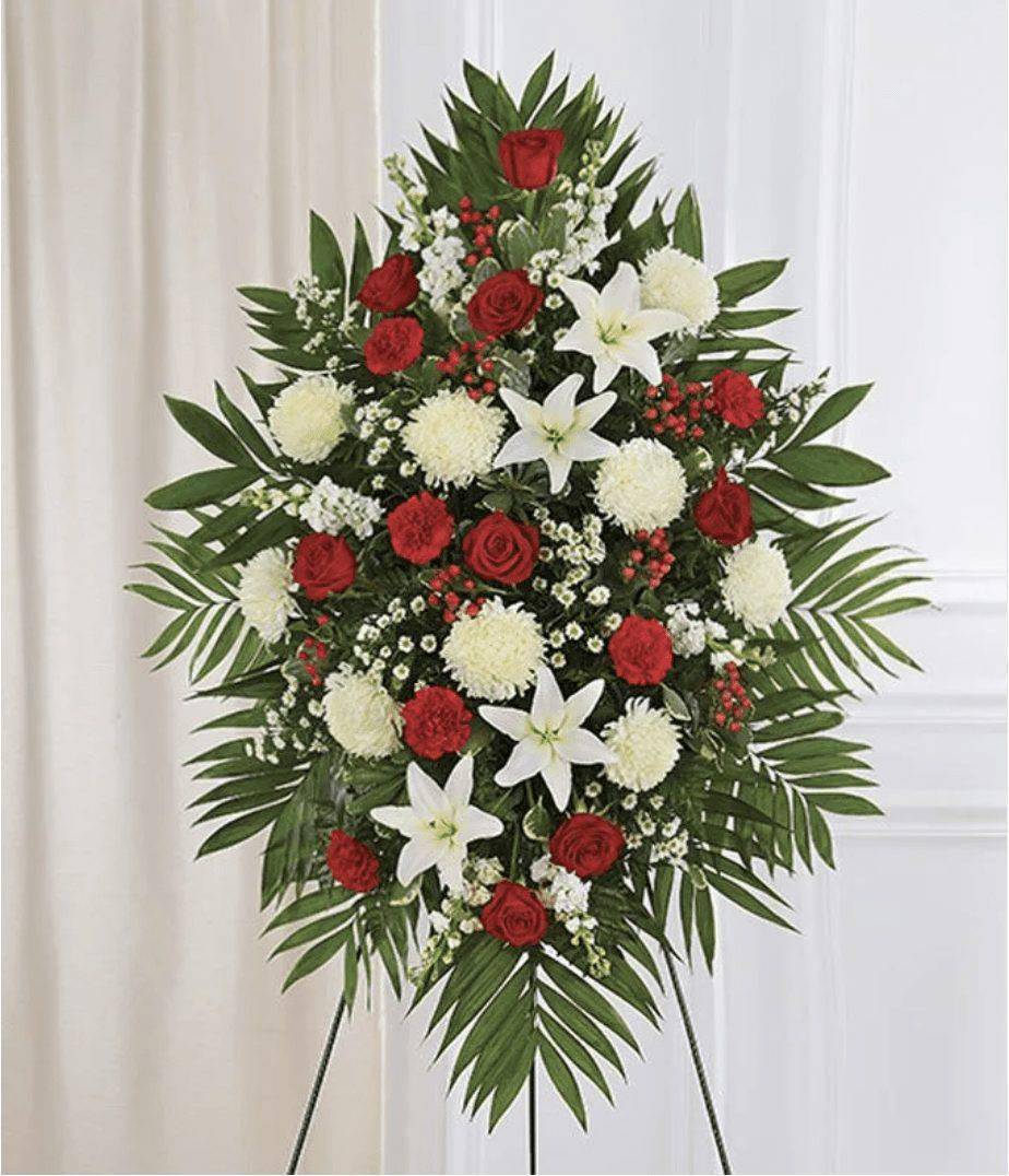 Standing floral spray with red roses, white lilies, and white pompons