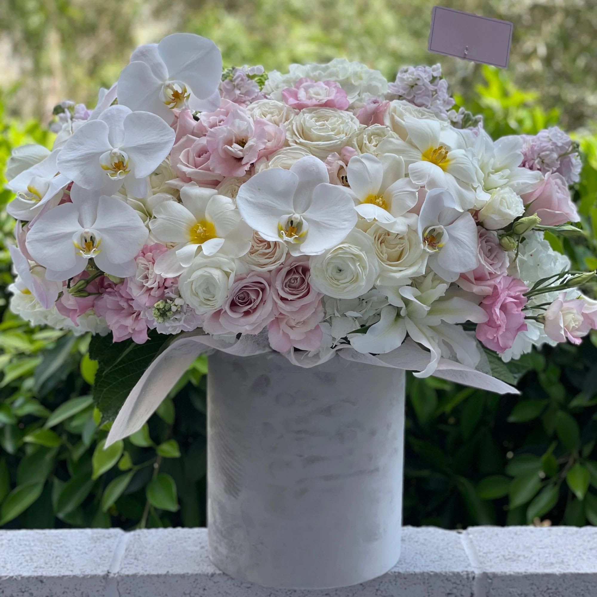 Pink and white floral arrangement in a tall gray vase