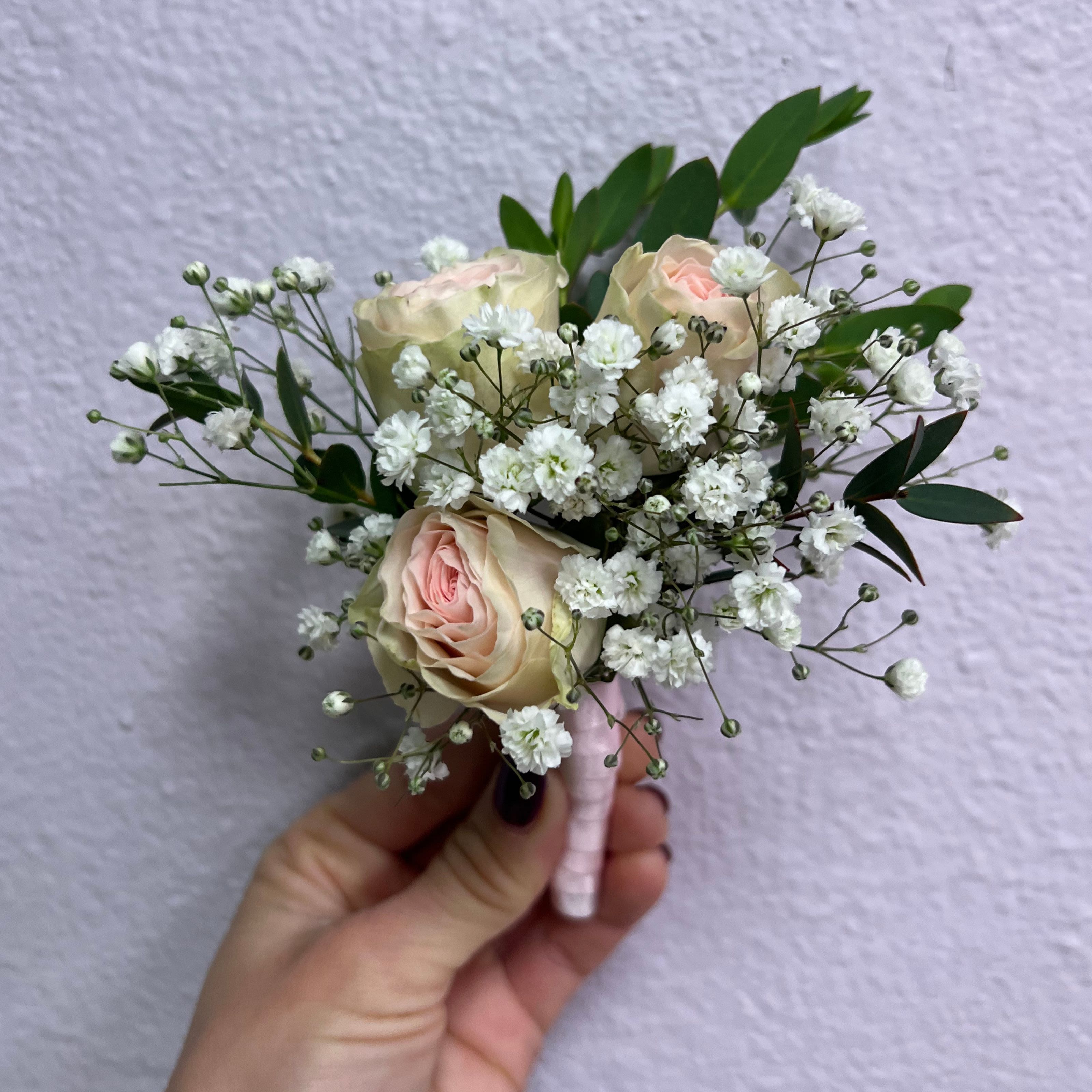 Small bouquet of pale pink roses and white baby's breath