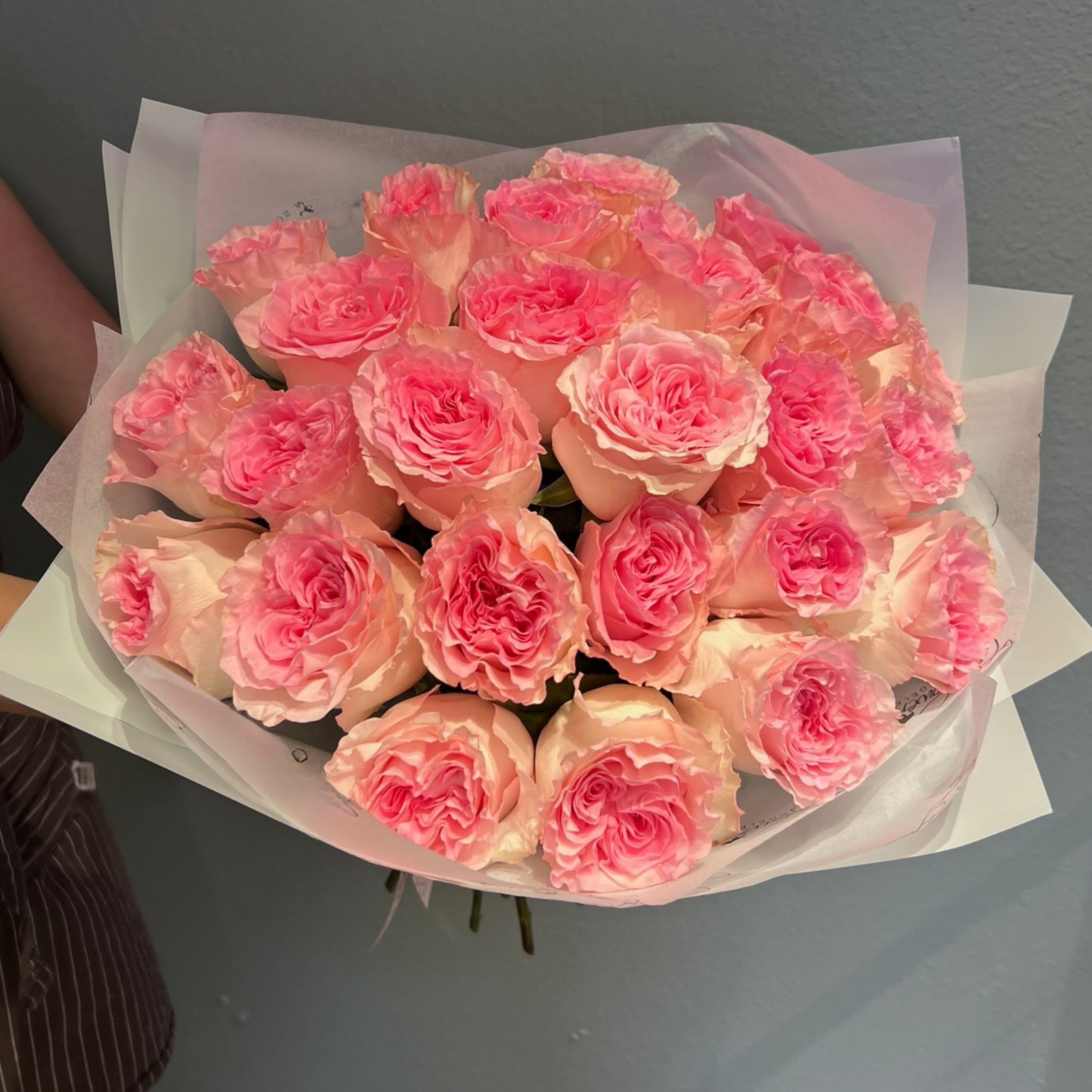 Bouquet of pink roses wrapped in pale paper