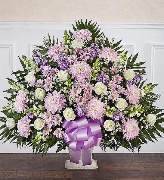 Heartfelt Tribute.Lavender &amp; White Floor Basket - In times of loss, expressing the love you feel in your heart is not always easy. Our elegant floor basket arrangement in graceful hues, handcrafted by our caring florists with soothing lavender and white blooms, is a tasteful gesture perfectly suited for the funeral home or memorial services.Floor basket arrangement of lavender daisy poms, football mums, and stock; white roses, snapdragons and monte casino; accented with soft, lush greenery