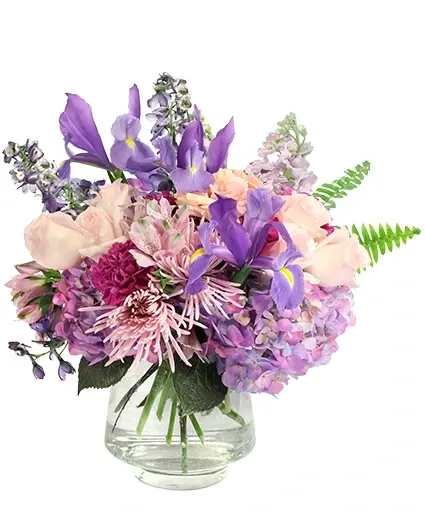 Purple and pink mixed bouquet in a clear glass vase