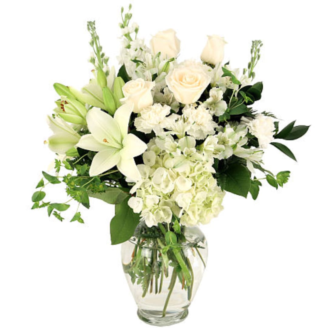 White roses and lilies arranged in a clear glass vase