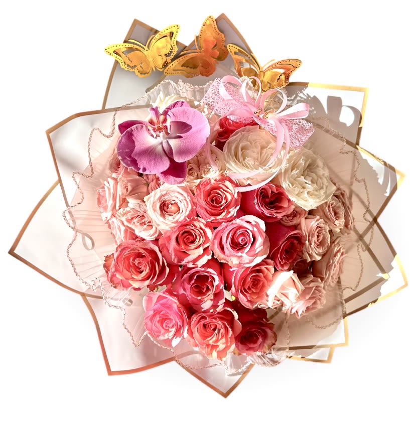 Coquette Dream Bouquet  - A tightly clustered round bouquet that looks like a romantic daydream - blush, coral, soft pink, creamy ivory and peach roses form a lush dome while a single Phalaenopsis orchid in lavender-to-pink rests on top as an exotic, sculptural focal point. Framed in layered scalloped paper wraps with a sheer ruffled overlay and finished with a lacy pink ribbon bow, the Coquette Dream Bouquet reads feminine and celebratory; metallic gold and yellow butterfly picks add a whimsical lift that catches the eye.  Perfect for anniversaries, birthdays, Mother's Day, quinceañeras or any "thinking of you" moment, this arrangement says "you are adored" with a mix of classic romance and modern flair. The bouquet's round, tightly packed shape creates a full visual impact and ships gift-ready in its decorative wrap - the kind of present that makes the recipient feel genuinely celebrated.