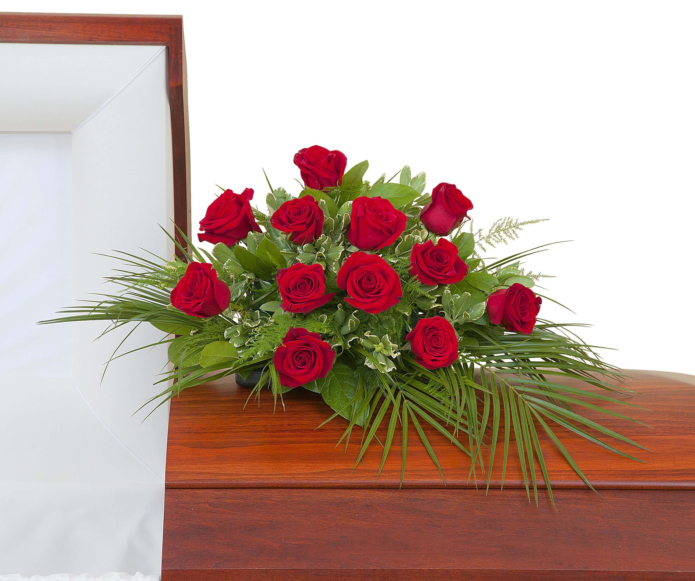 Red rose casket spray arranged on a polished wooden casket