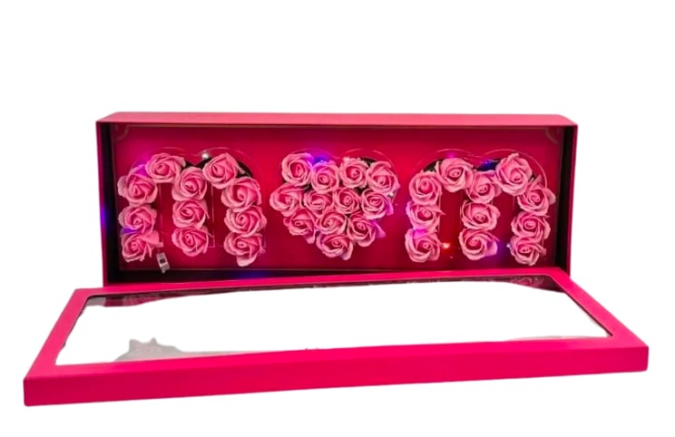 Pink box of roses spelling MOM with a heart shape in the center and small colored lights inside