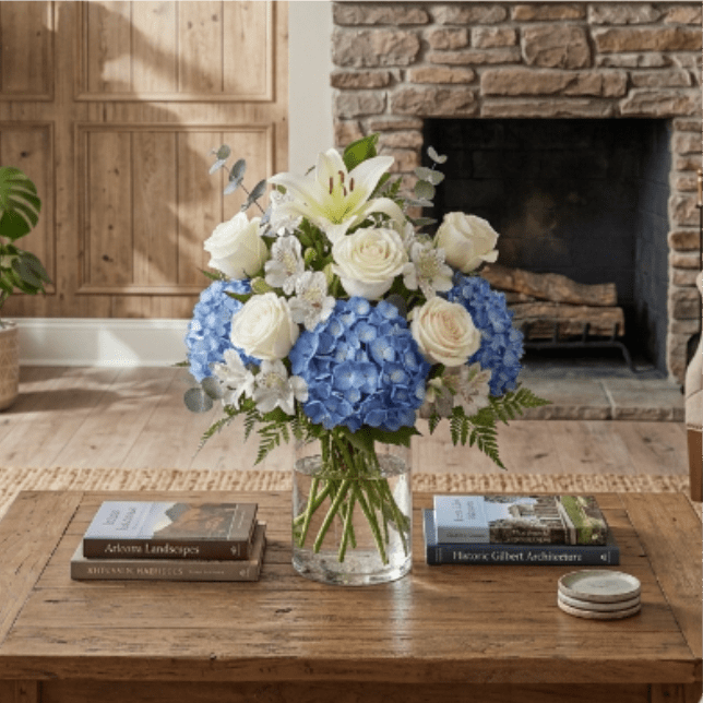 Heavenly Blue Blessing - Welcome the newest little blessing with Heavenly Blue Blessing, an elegant and tranquil arrangement. Lush blue hydrangeas form a cloud-like base, beautifully contrasted by pristine white roses and a radiant white Asiatic lily, symbolizing purity and new beginnings. Delicate white alstroemeria adds intricate texture, while soft eucalyptus and verdant ferns provide a fresh, natural embrace. This serene bouquet is a heartfelt and sophisticated tribute to the joy of a baby's arrival. 