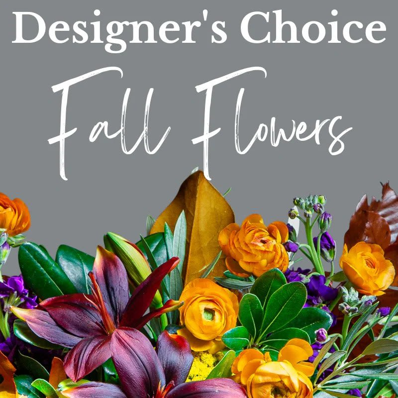 Designer’s choice sign above an arrangement of burgundy lilies and orange and purple fall flowers