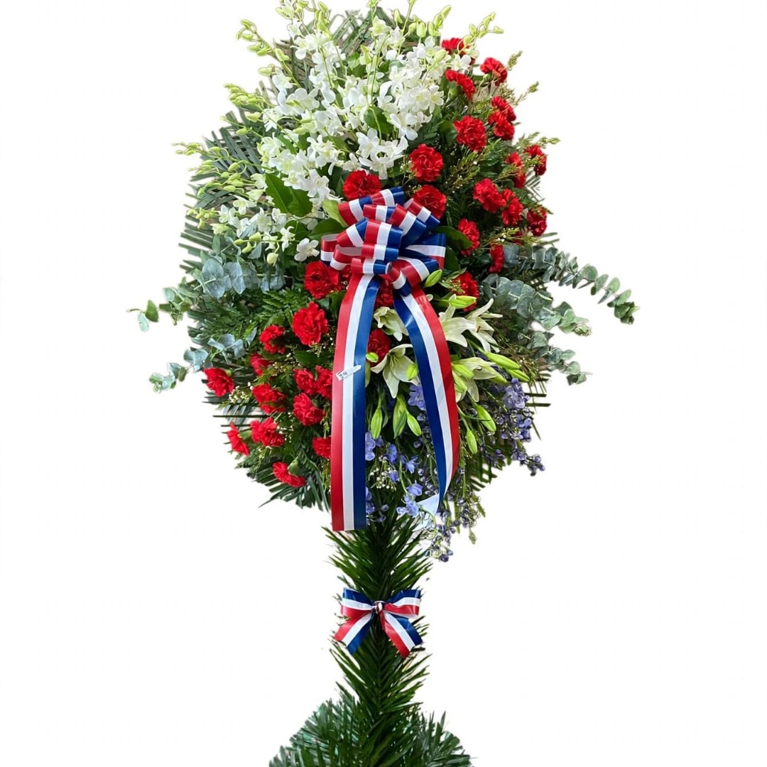 Tall standing floral spray with red and white flowers and a red-white-blue ribbon