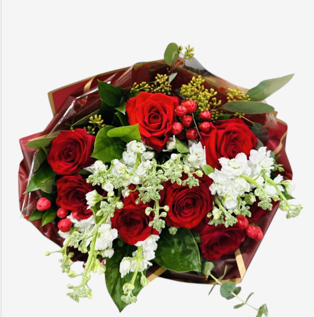 Bouquet of red roses with white flowers and greenery in burgundy wrap
