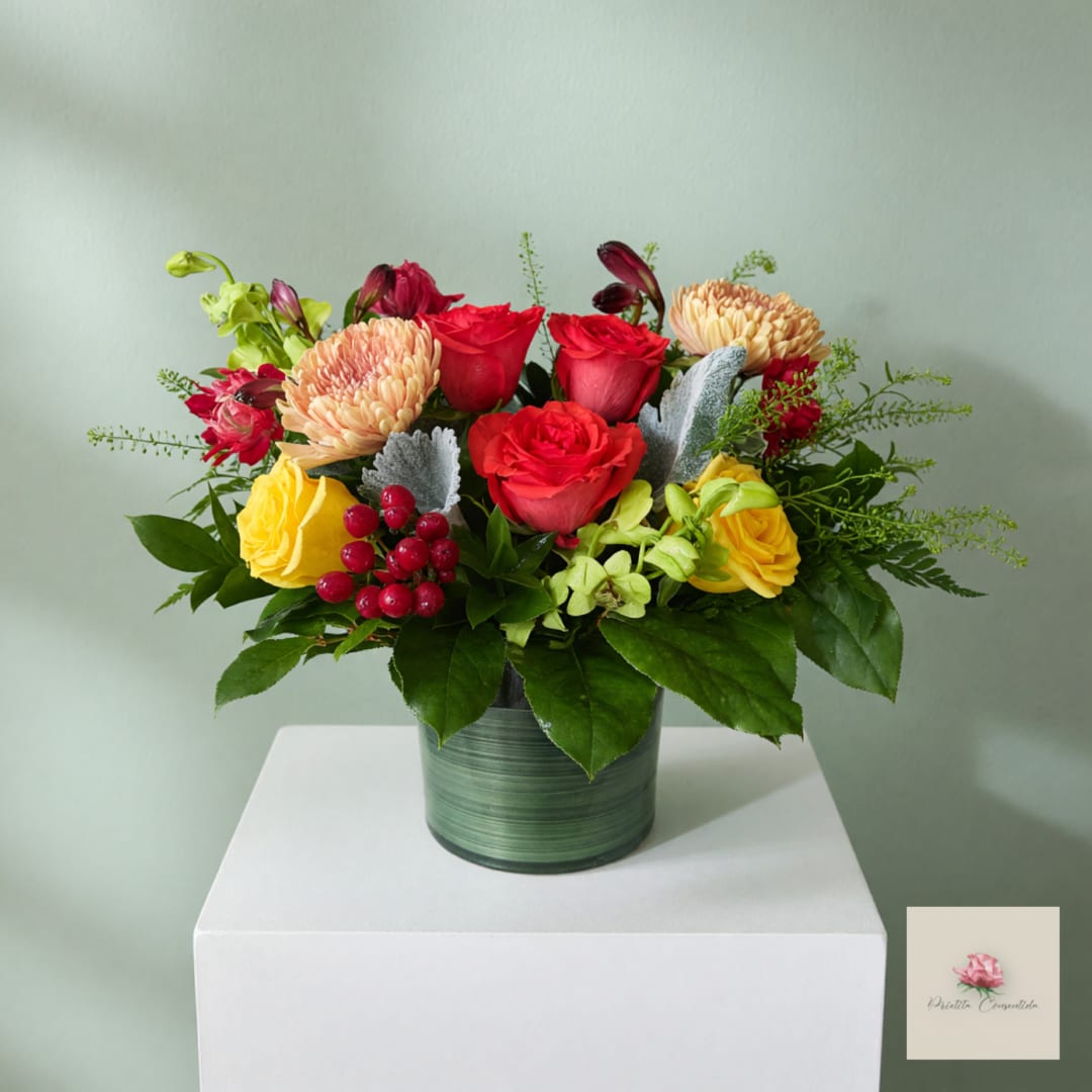 Mixed bouquet of red, yellow, and peach flowers in a green vase