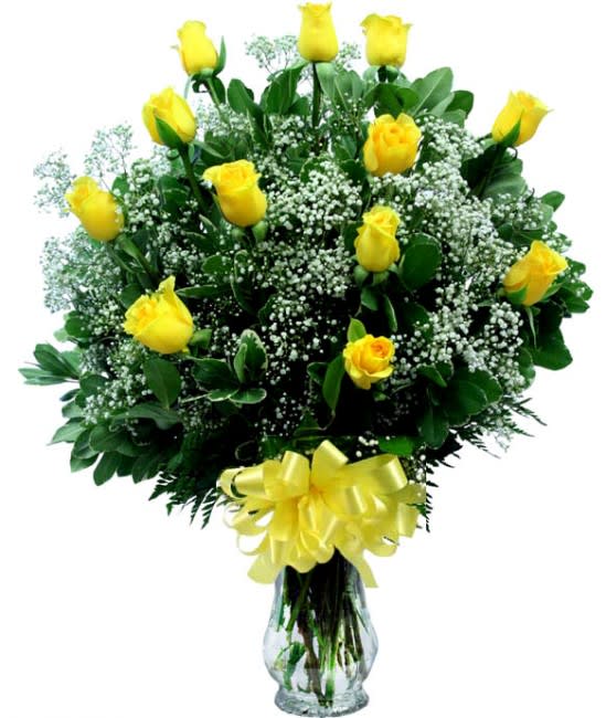 Yellow roses in a glass vase with baby's breath and a yellow bow