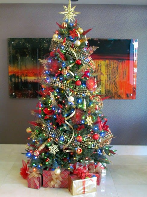 Decorated Christmas tree with lights, ornaments, and wrapped gifts underneath