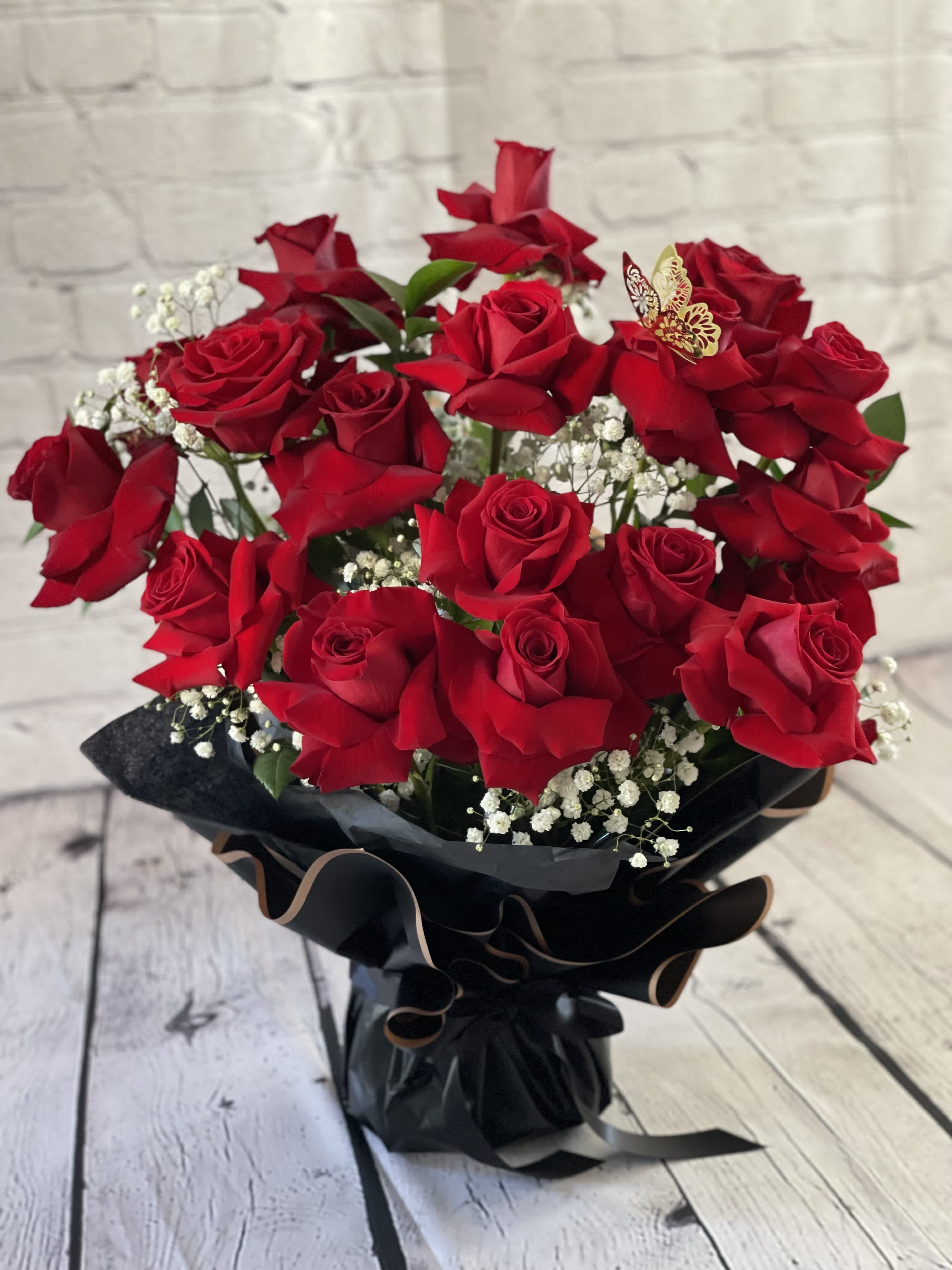 Bouquet of red roses with baby's breath in black wrap