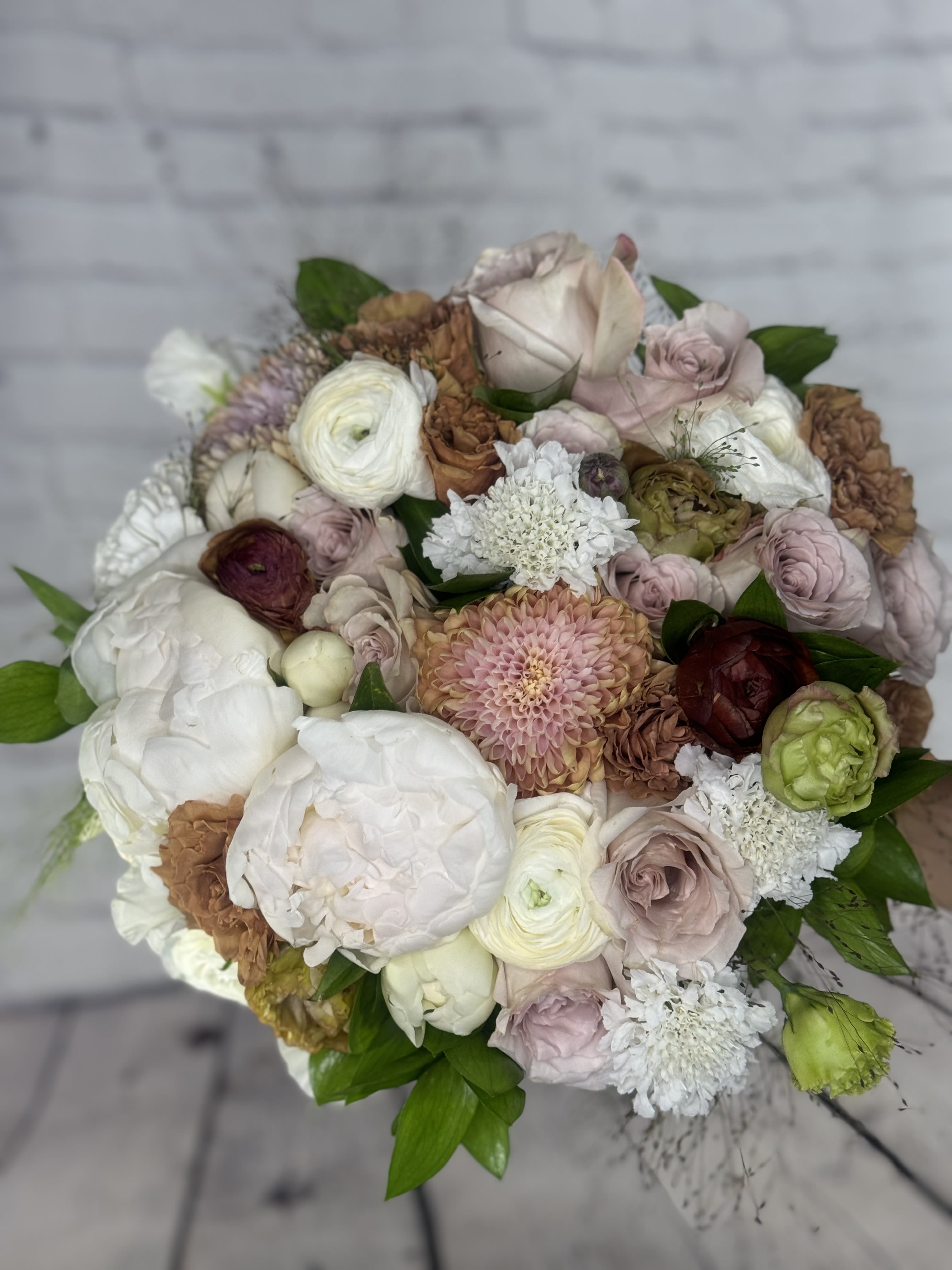 Round bouquet of blush, white, and brown flowers