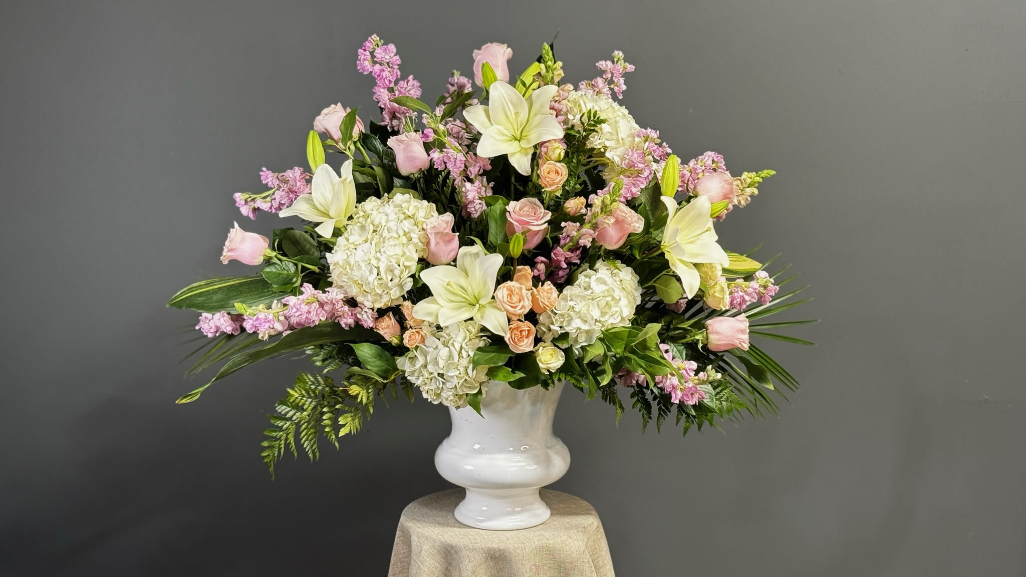 Pink and white floral arrangement in a white vase