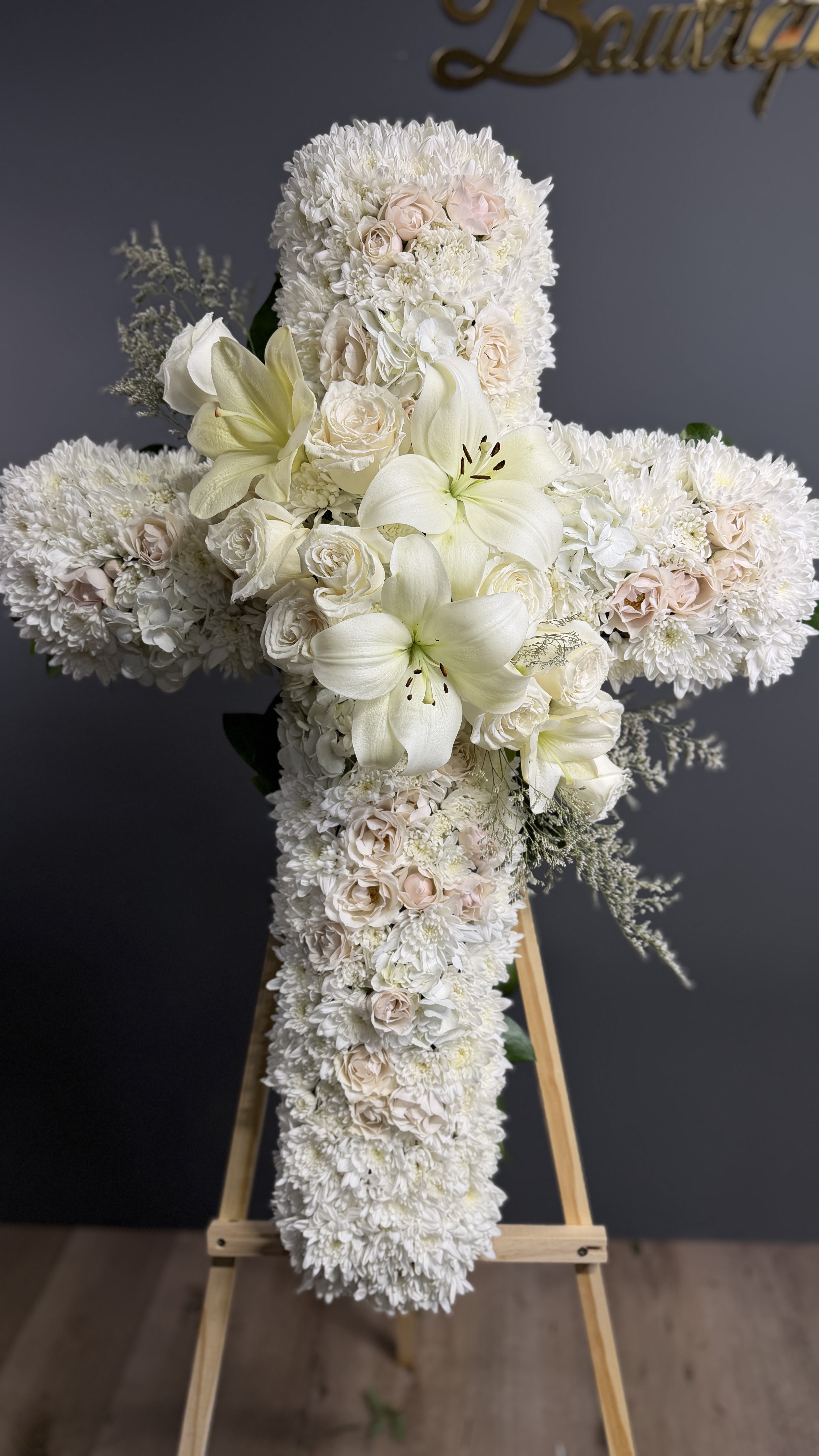 Faith  - An all white tribute, this white cross funeral spray is pure and tranquil. Featuring a variety of white flowers, this elegant easel compliments the beauty of life. 