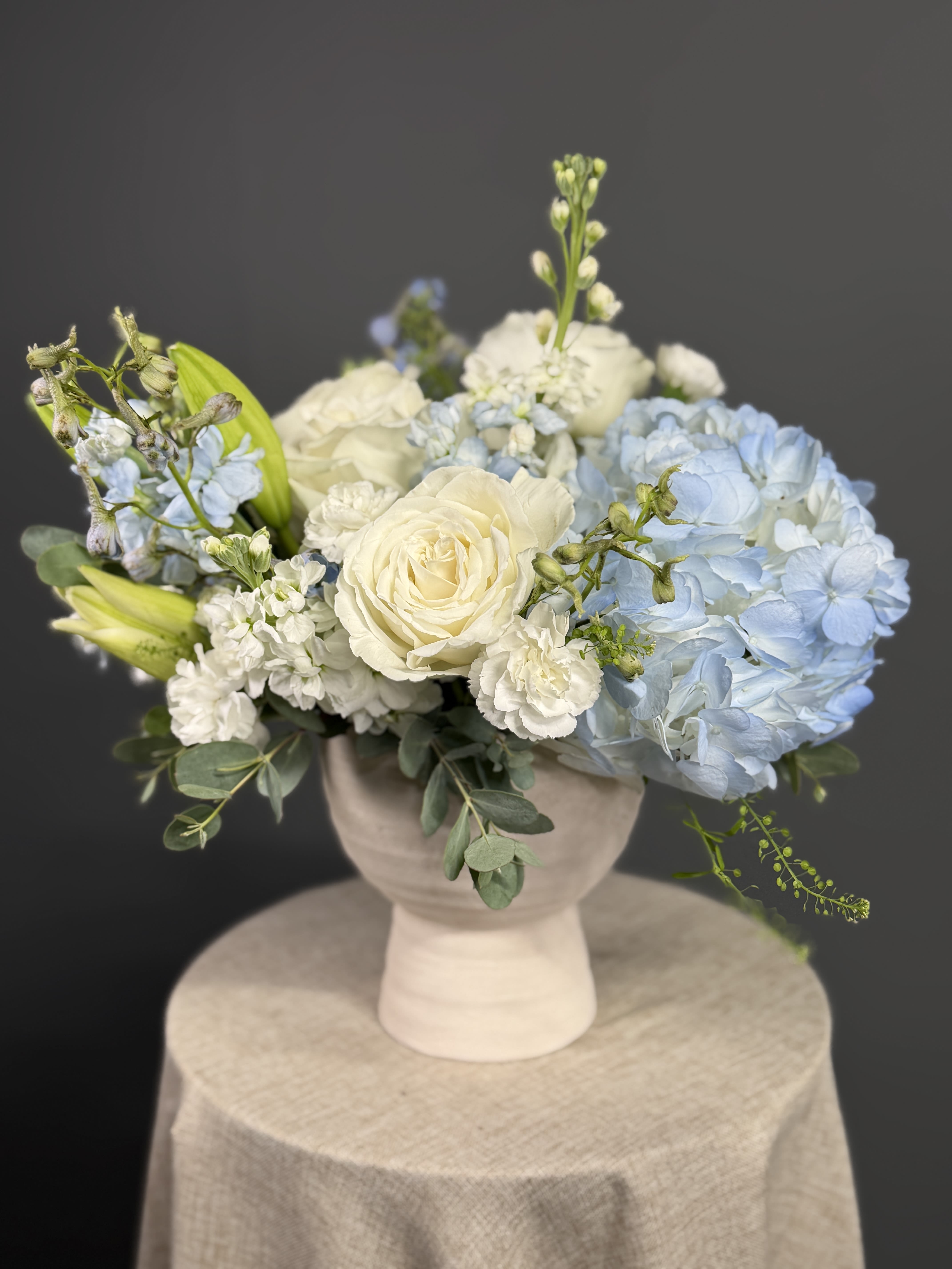 Cloud Nine Elegance - A dreamy mix of fluffy hydrangeas, classic white roses, and textured accents, arranged in a neutral vase for timeless sophistication.