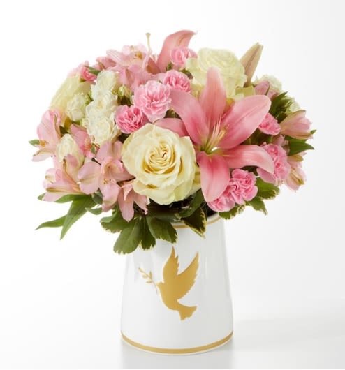 Pink and cream bouquet in a white vase with a gold dove design