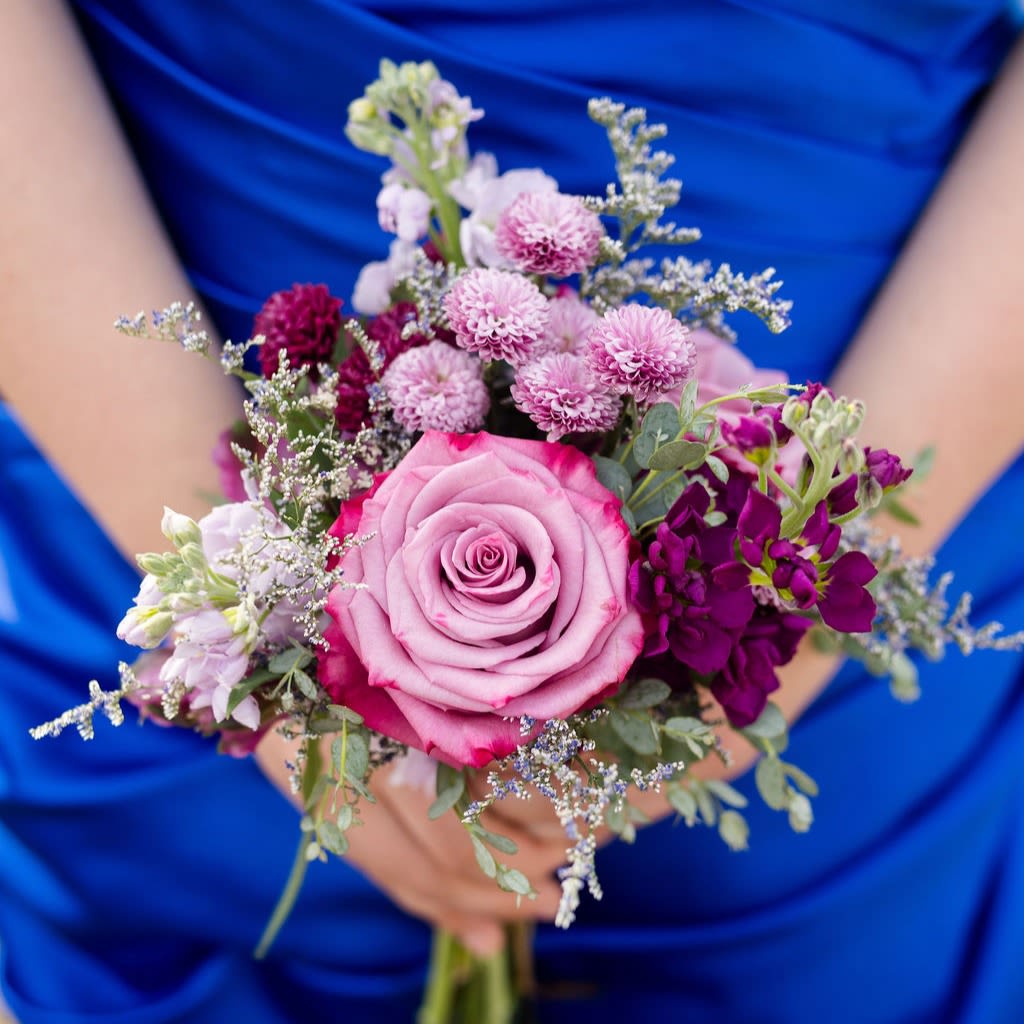 Breckenridge - A delicate collection of lilac, lavender and purple blooms in a posy bouquet~ perfect for holding in photos!  Pick up dates for prom are Saturday, April 18th, April 25th and May 2nd. Please call if you need to order this for a different event.