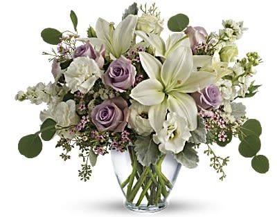 Lavender roses and white lilies in a clear glass vase