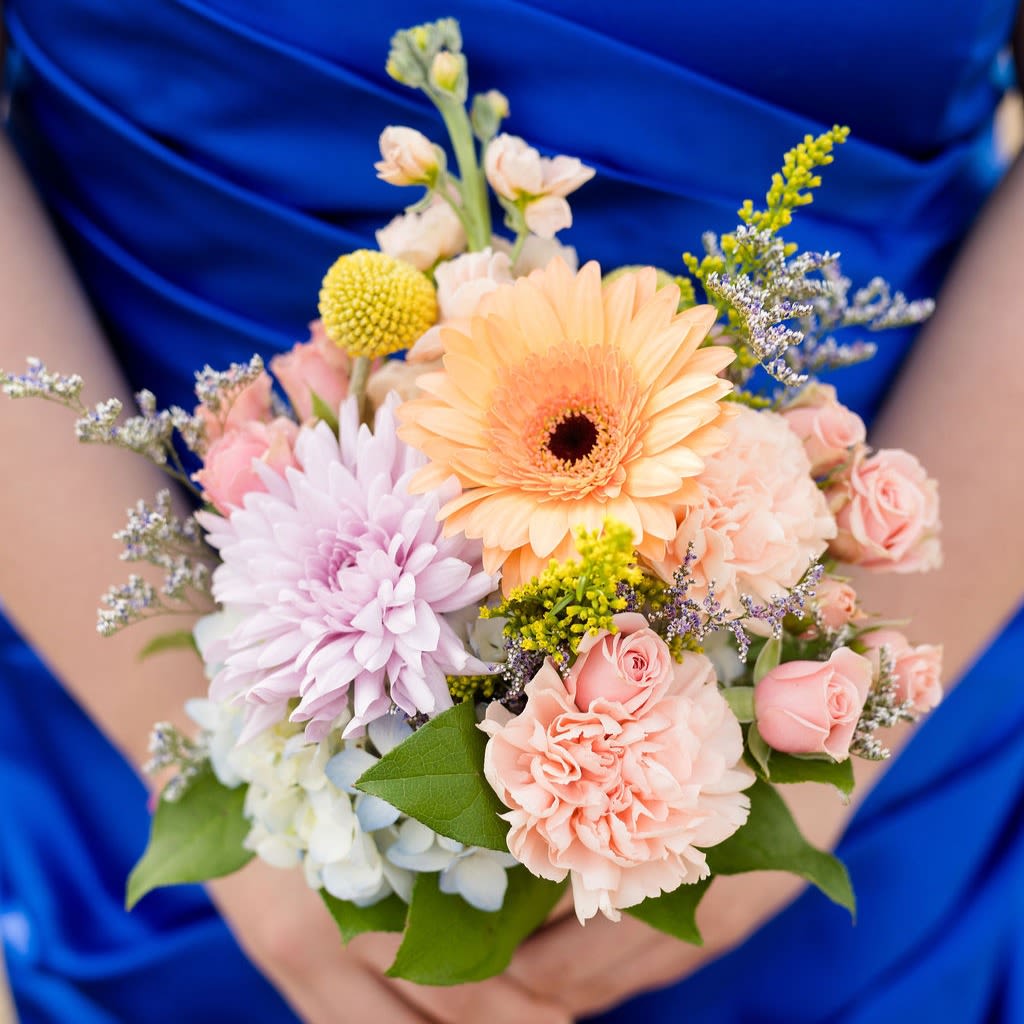 Valencia - A pastel collection of blooms in a posy bouquet that includes blooms in blush, peach, ivory, buttercream and lavender tones~ perfect for holding in photos!  Pick up dates for prom are Saturday, April 18th, April 25th and May 2nd. Please call if you need to order this for a different event.