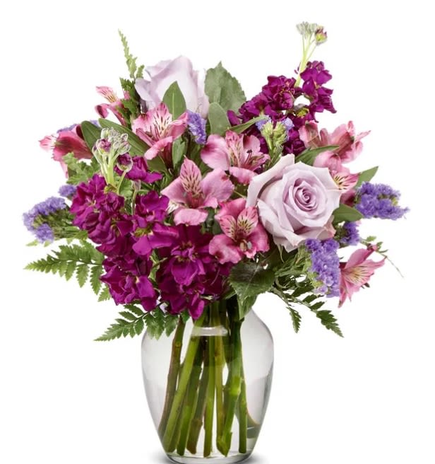 Bouquet of pink and purple flowers in a clear glass vase