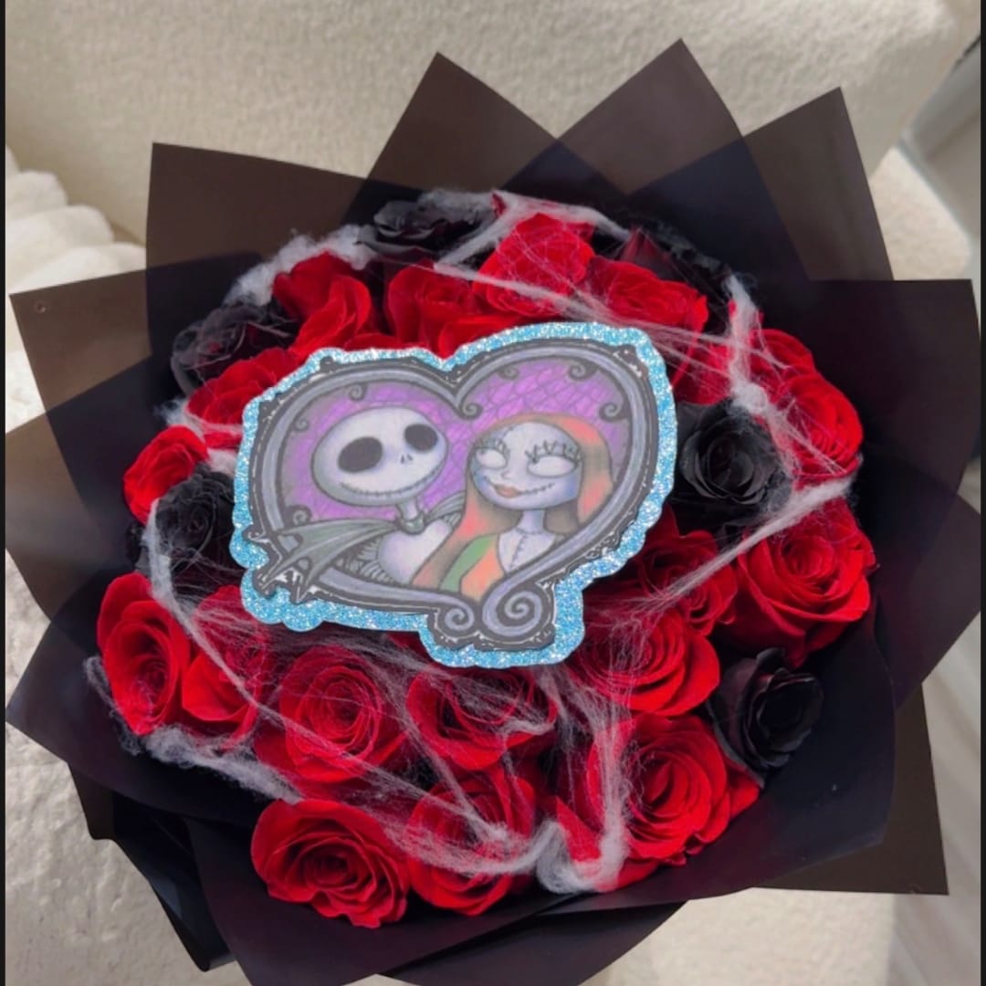 Bouquet of red and black roses with a decorative character topper