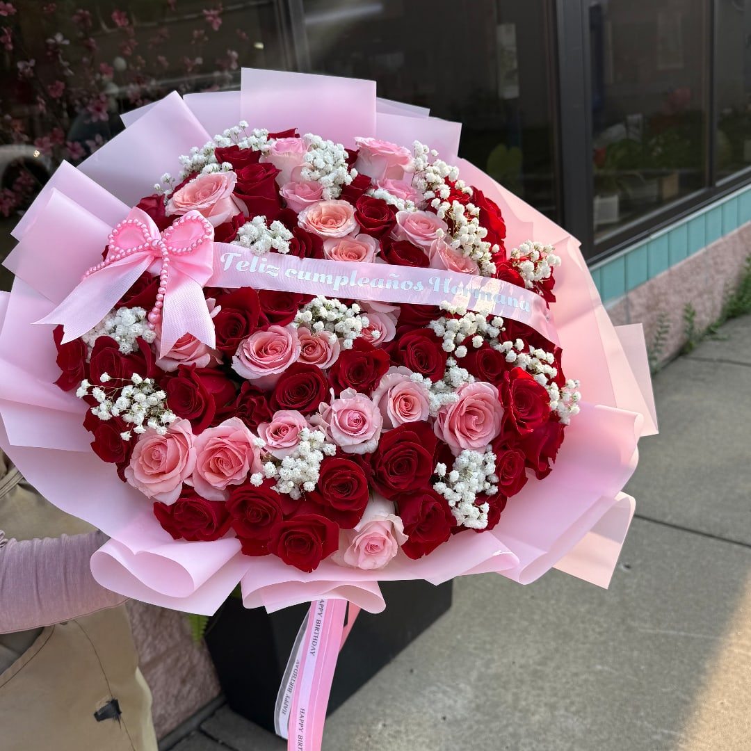 Large bouquet of red and pink roses with a pink birthday ribbon