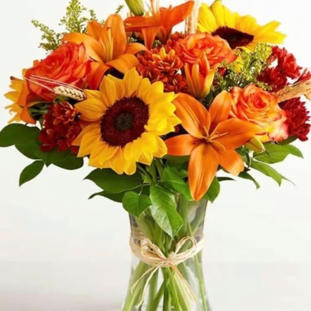 Bouquet of orange and yellow flowers in a clear glass vase