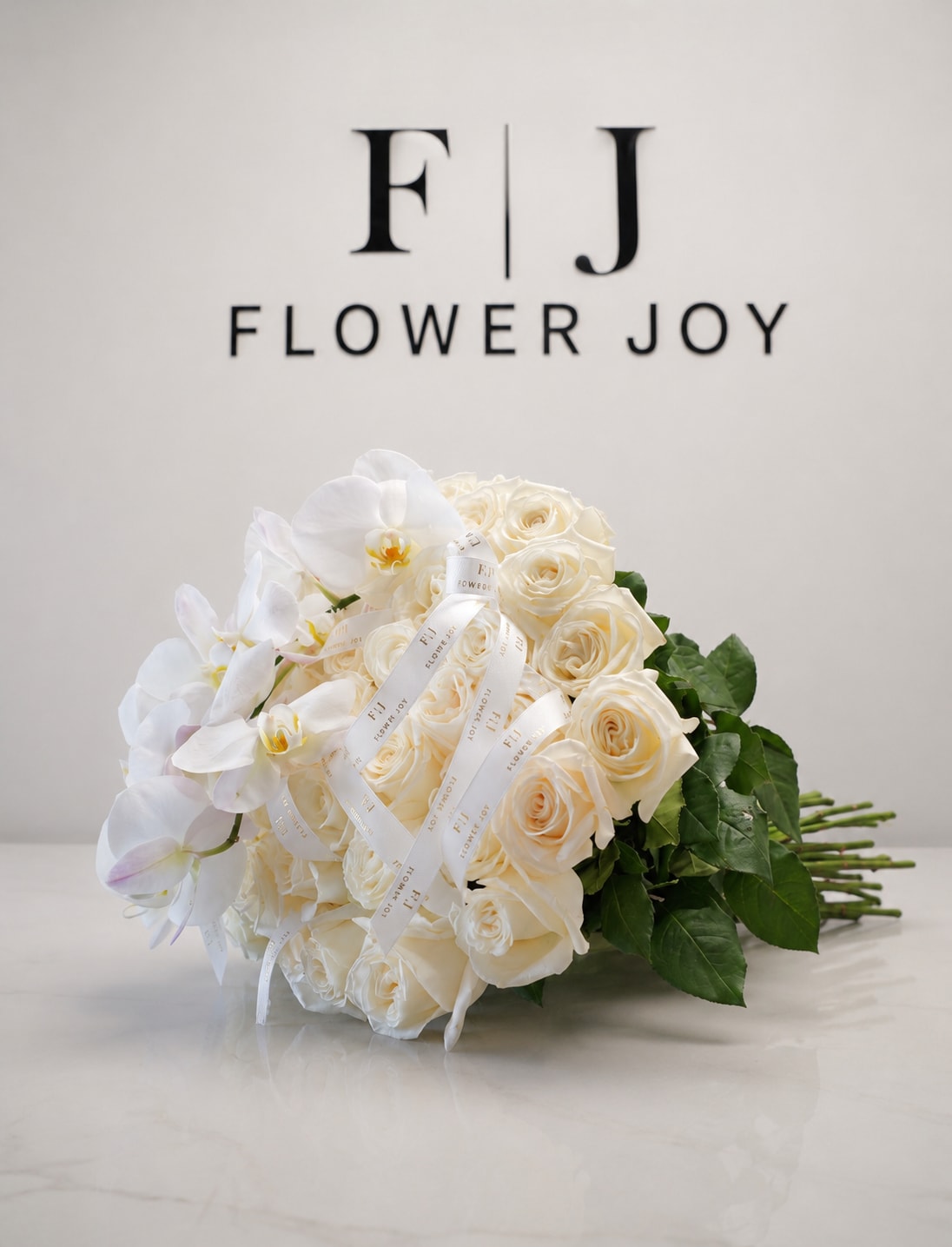 Pure Elegance Bouquet (50 items) - A graceful arrangement of ivory roses and delicate white orchids, finished with elegant ribbon details. Timeless and refined, it is perfect for weddings, anniversaries, congratulations, or any meaningful celebration.