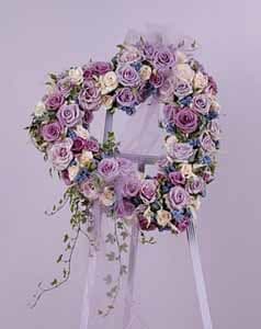 Lavender and pink rose wreath on a white stand