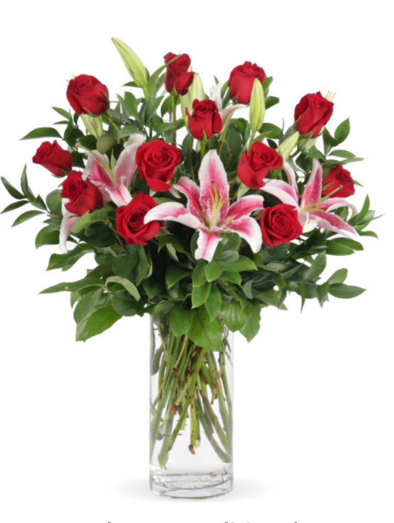 Red roses and pink lilies in a clear glass vase
