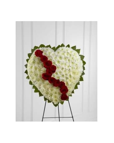 Heart-shaped floral standing spray with red roses on a white chrysanthemum base