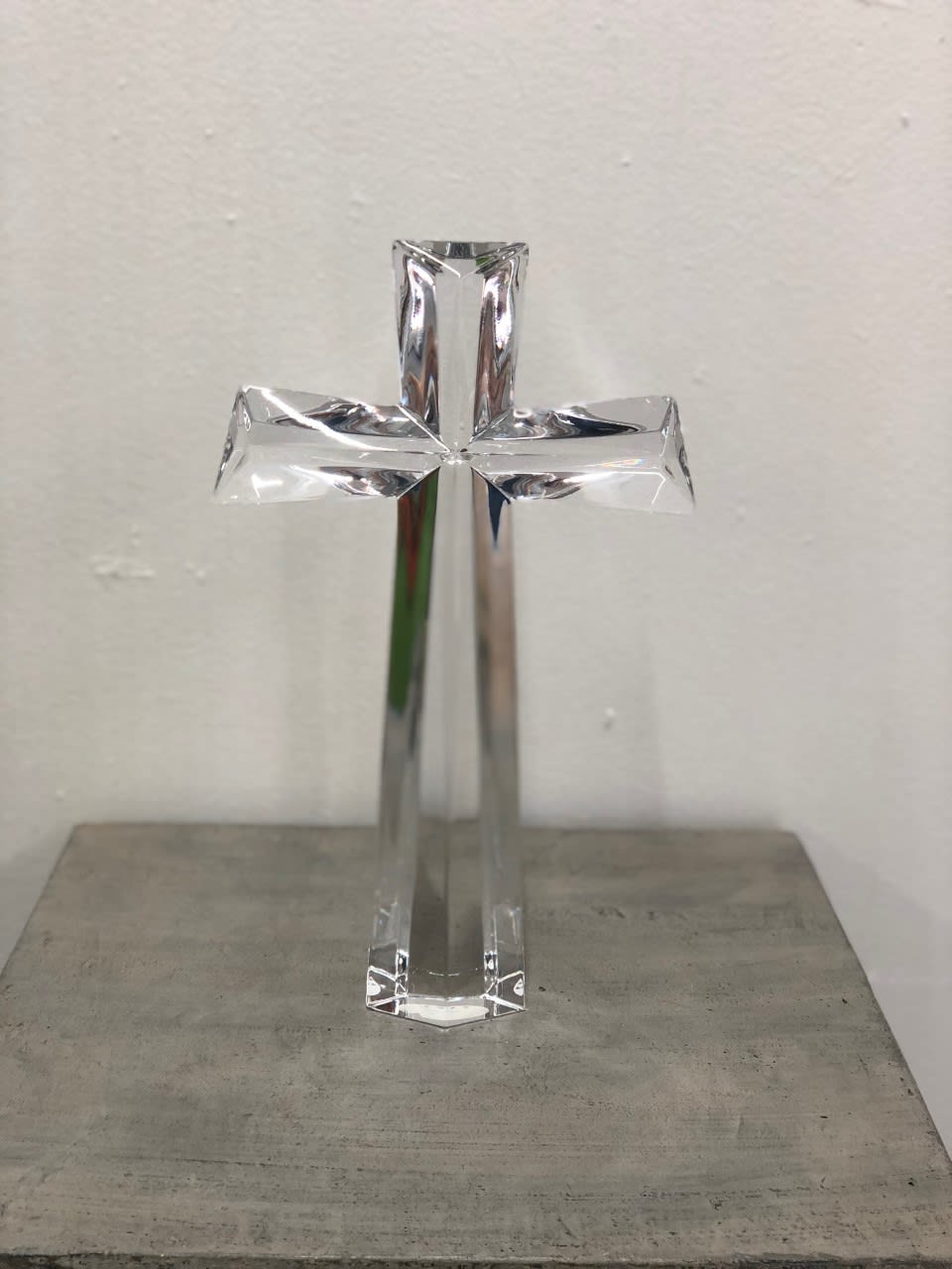 Clear glass cross standing on a surface