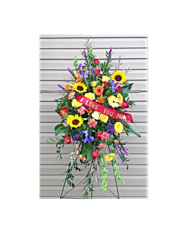 Standing floral spray with sunflowers, roses, and a red ribbon reading I LOVE YOU PAPA