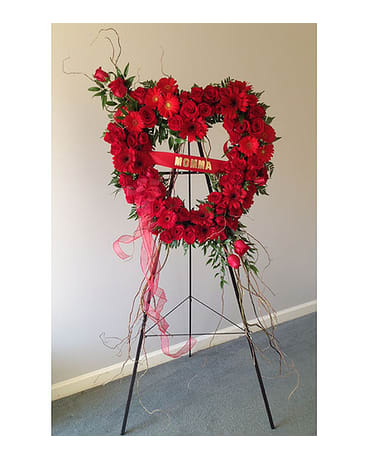Heart-shaped red floral standing spray on an easel