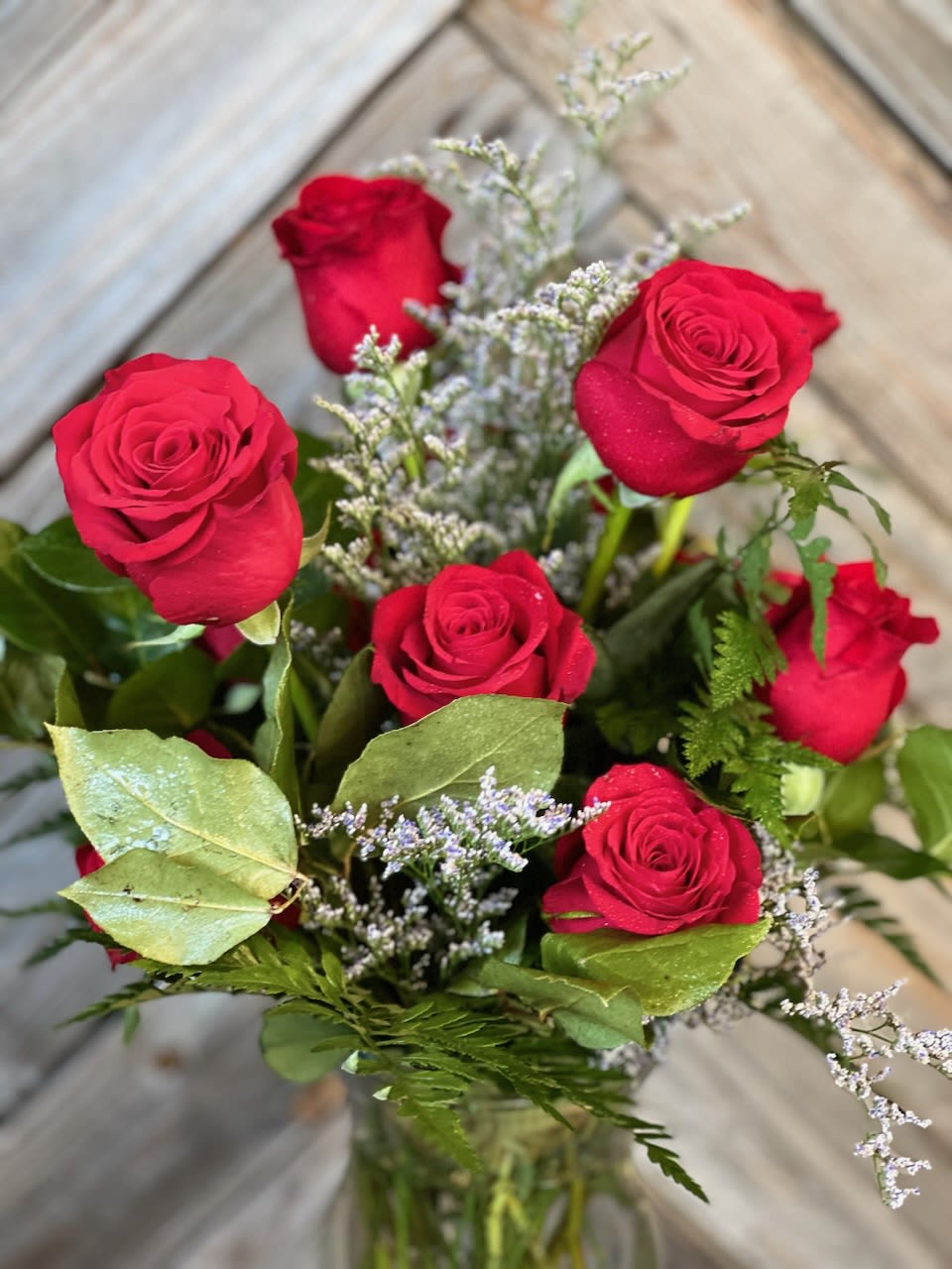 Bouquet of red roses with filler in a glass vase
