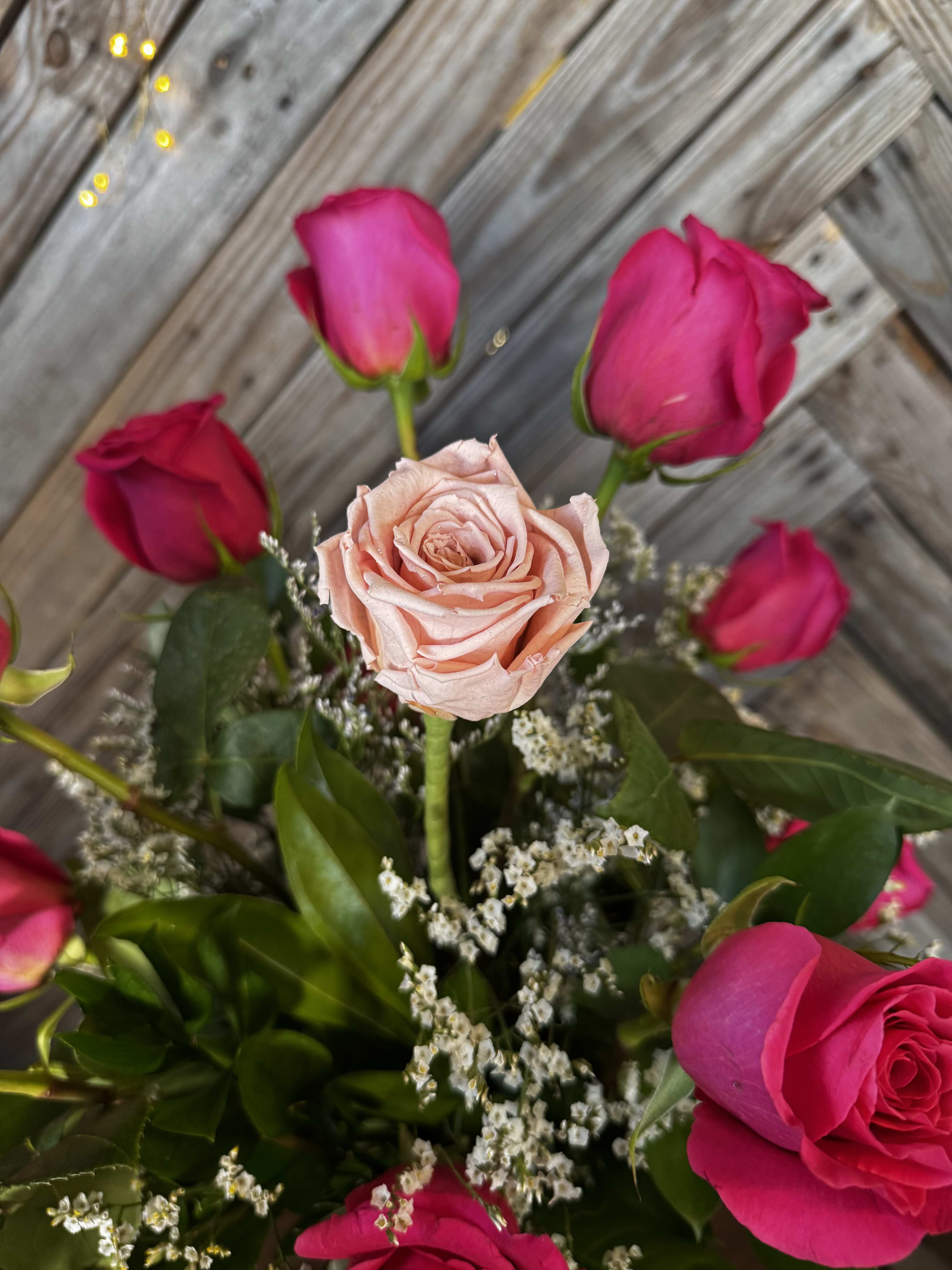Bouquet of pink roses with a pale peach rose in the center