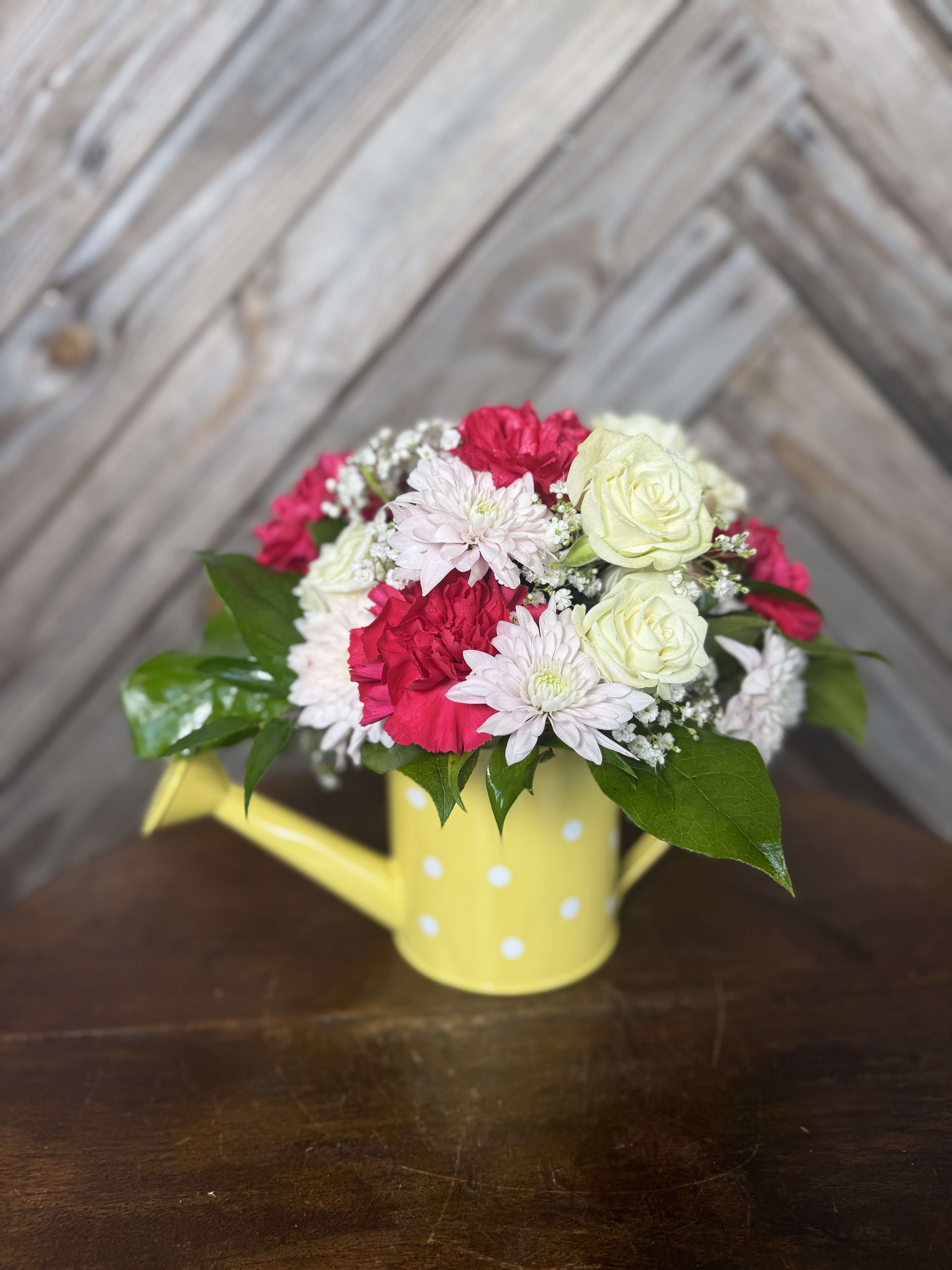 Watering Can Wishes - A sweet little watering can filled with love  Designed with fresh seasonal blooms in soft whites and bright pinks. Each one is unique and made to brighten her day this Mother’s Day.