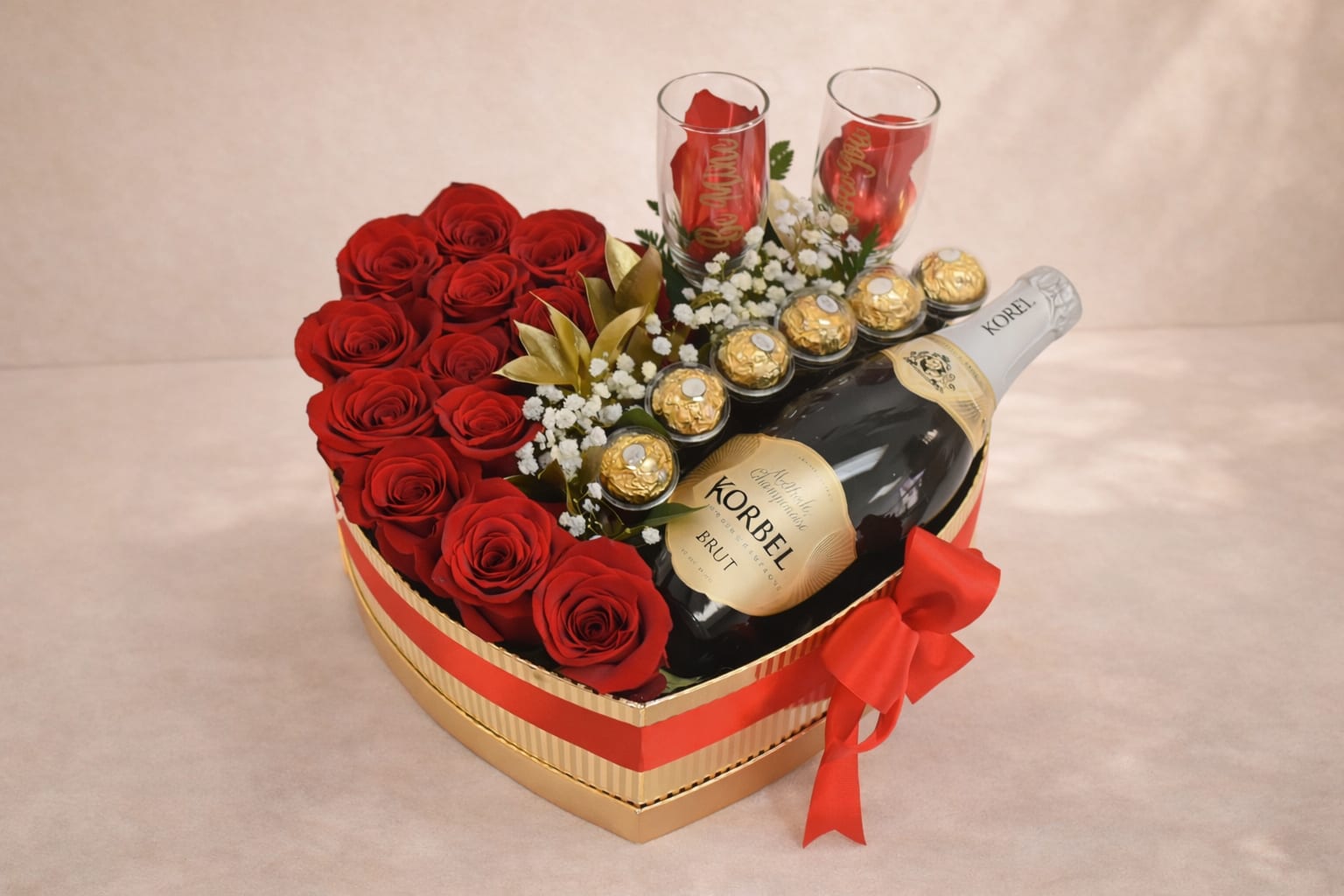 Heart-shaped gift box with red roses, chocolates, and two champagne flutes