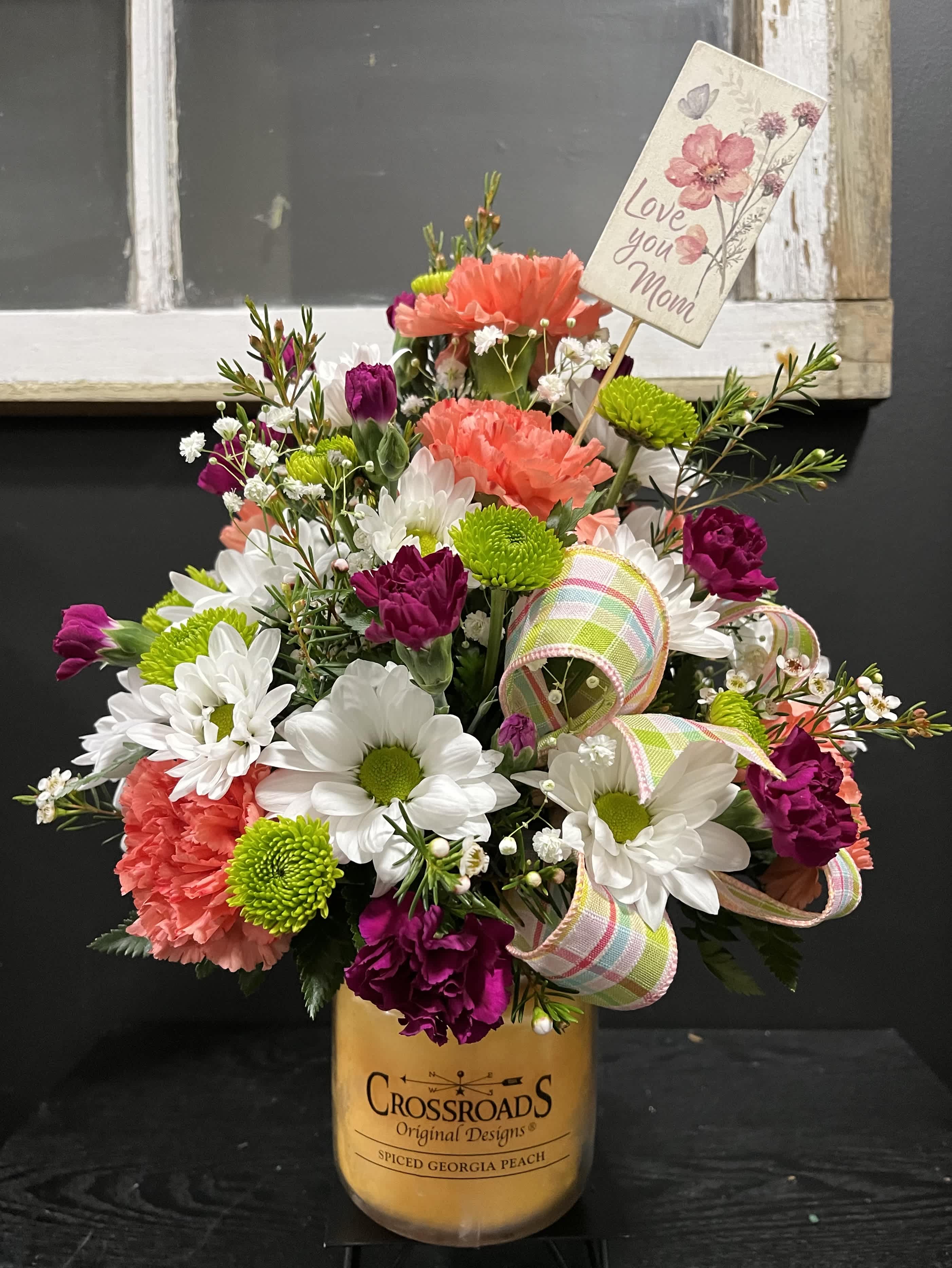 Mixed bouquet in a candle jar with a "Love you Mom" card