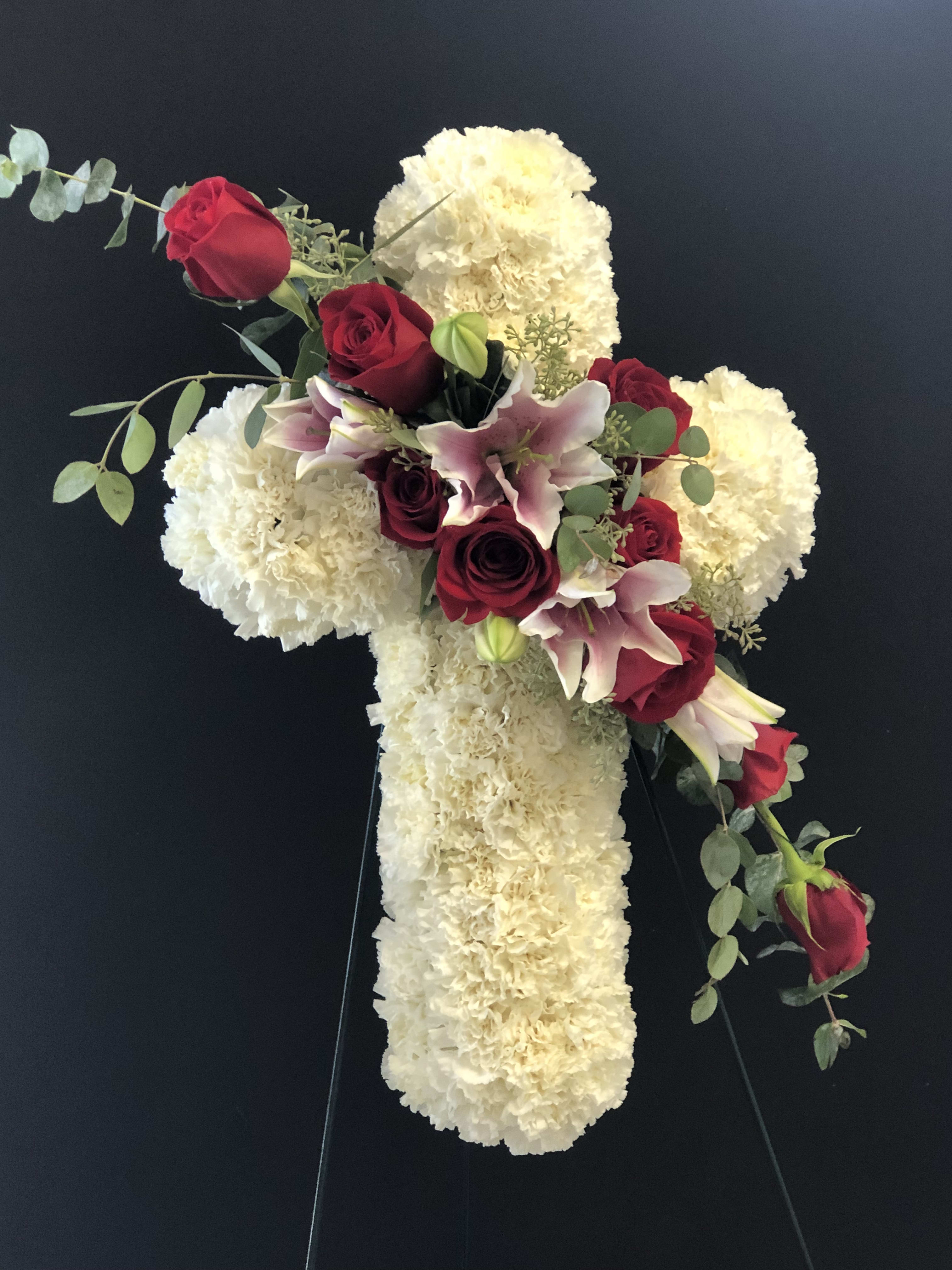 Cross-shaped floral tribute with red roses and white blooms