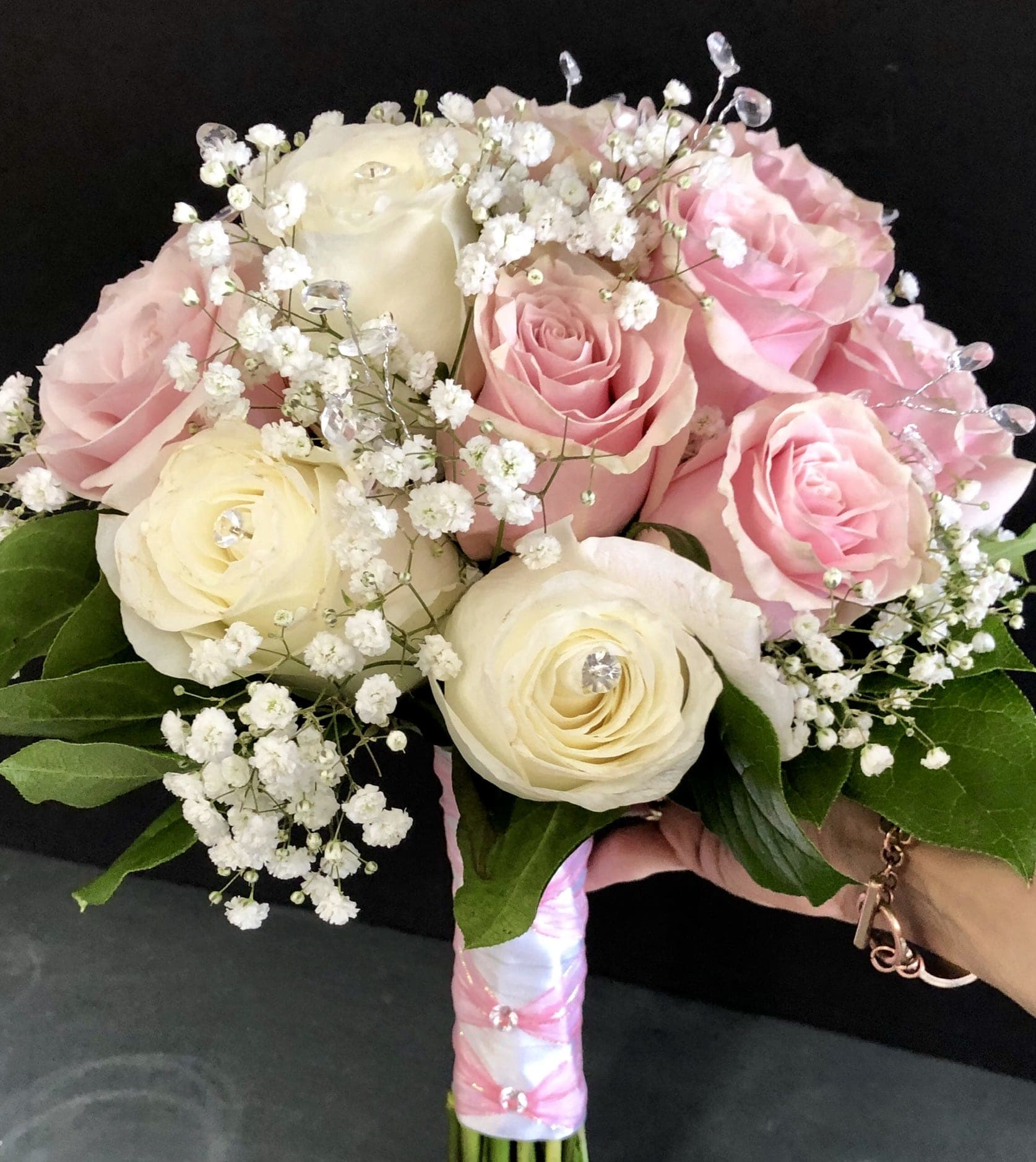 Pink and cream rose bouquet with baby's breath and a wrapped handle