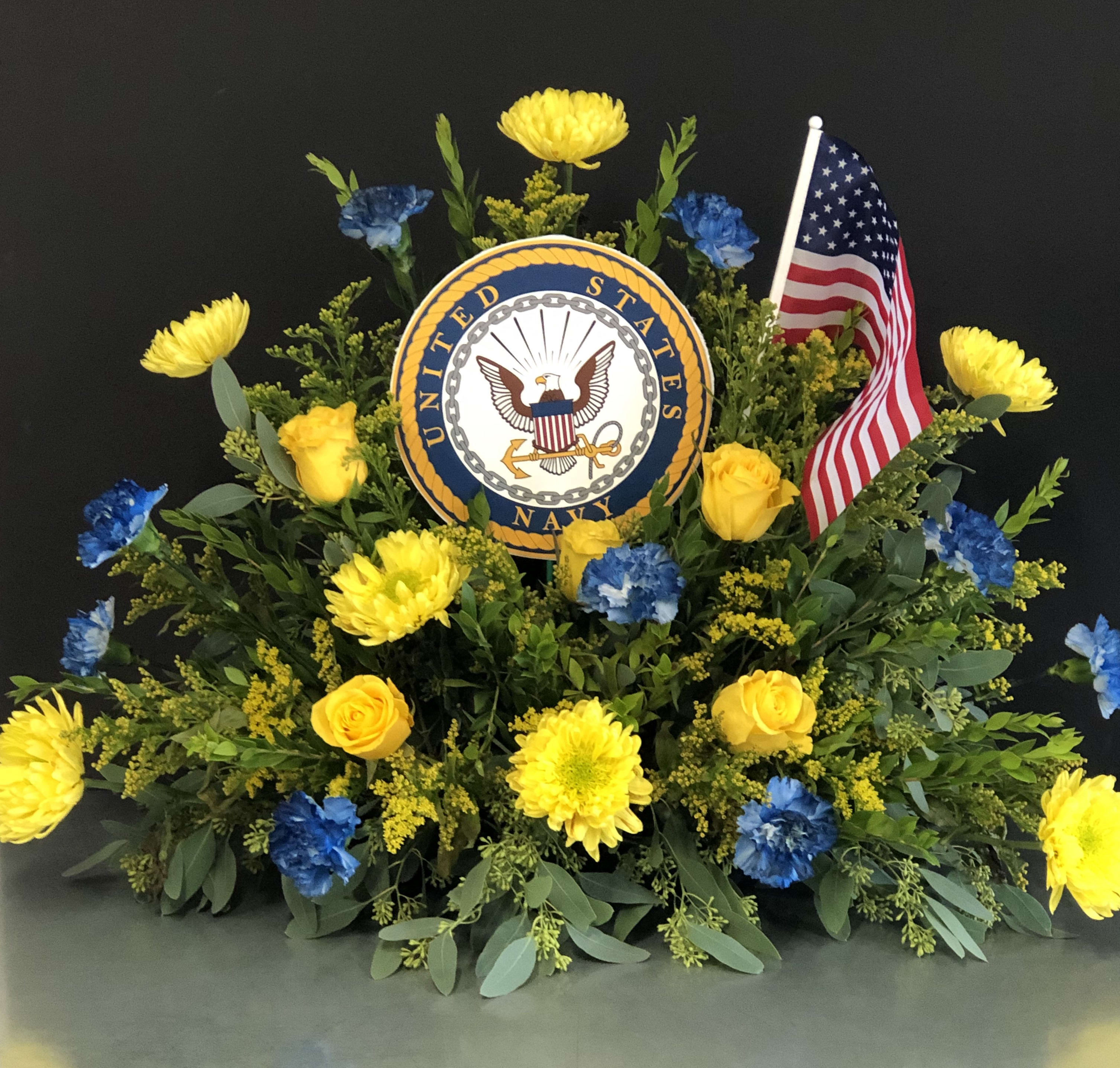 Yellow and blue floral tribute with a U.S. Navy emblem and American flag
