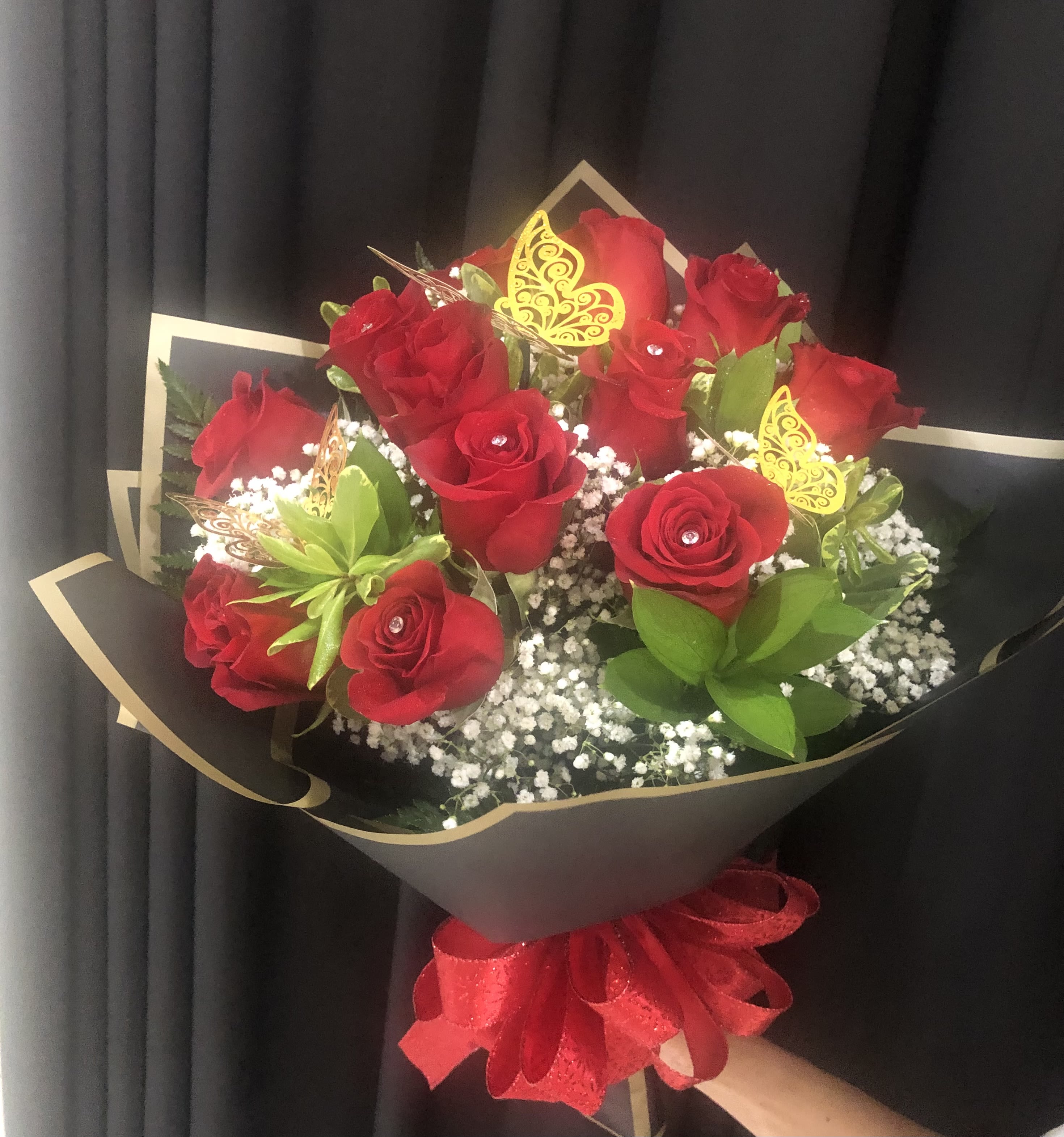 Bouquet of red roses with baby’s breath and gold butterfly picks