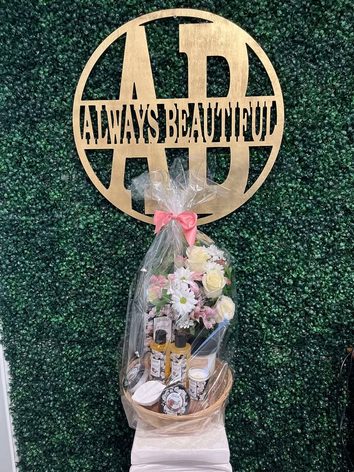 Gift basket with flowers, candles, and bath items wrapped in clear cellophane