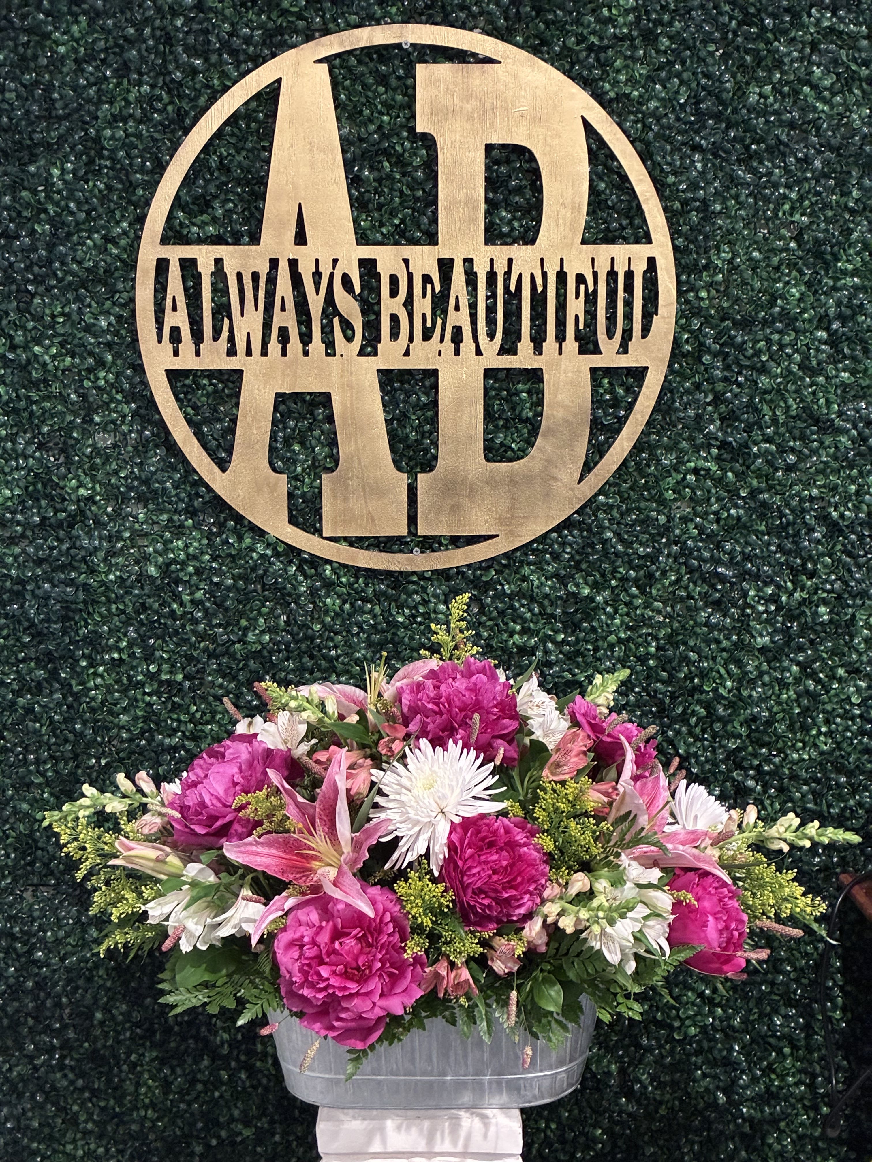 Pink and white floral arrangement in a silver container
